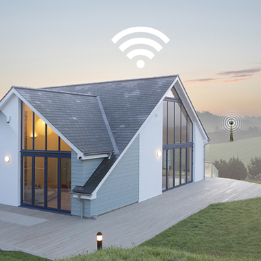 Modern ház nagy ablakokkal és Wi-Fi szimbólummal felette. Zöld fű és terasz elöl.