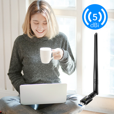 Nő laptop-pal. Mosolyog, csészét tart. USB antenna csatlakozik a laptophoz.