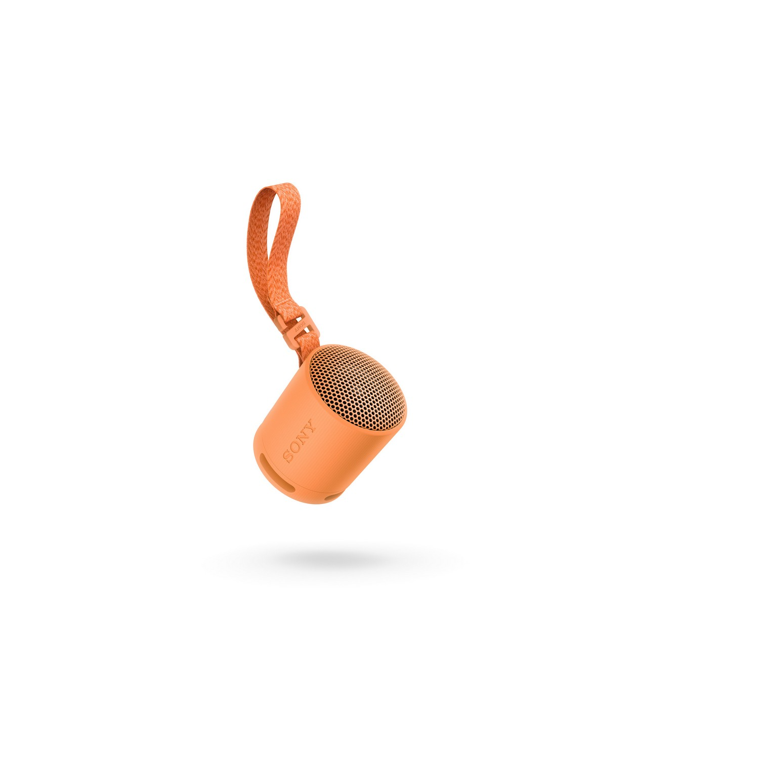 Haut-parleur orange, petit, portable avec une boucle orange, isolé sur blanc.