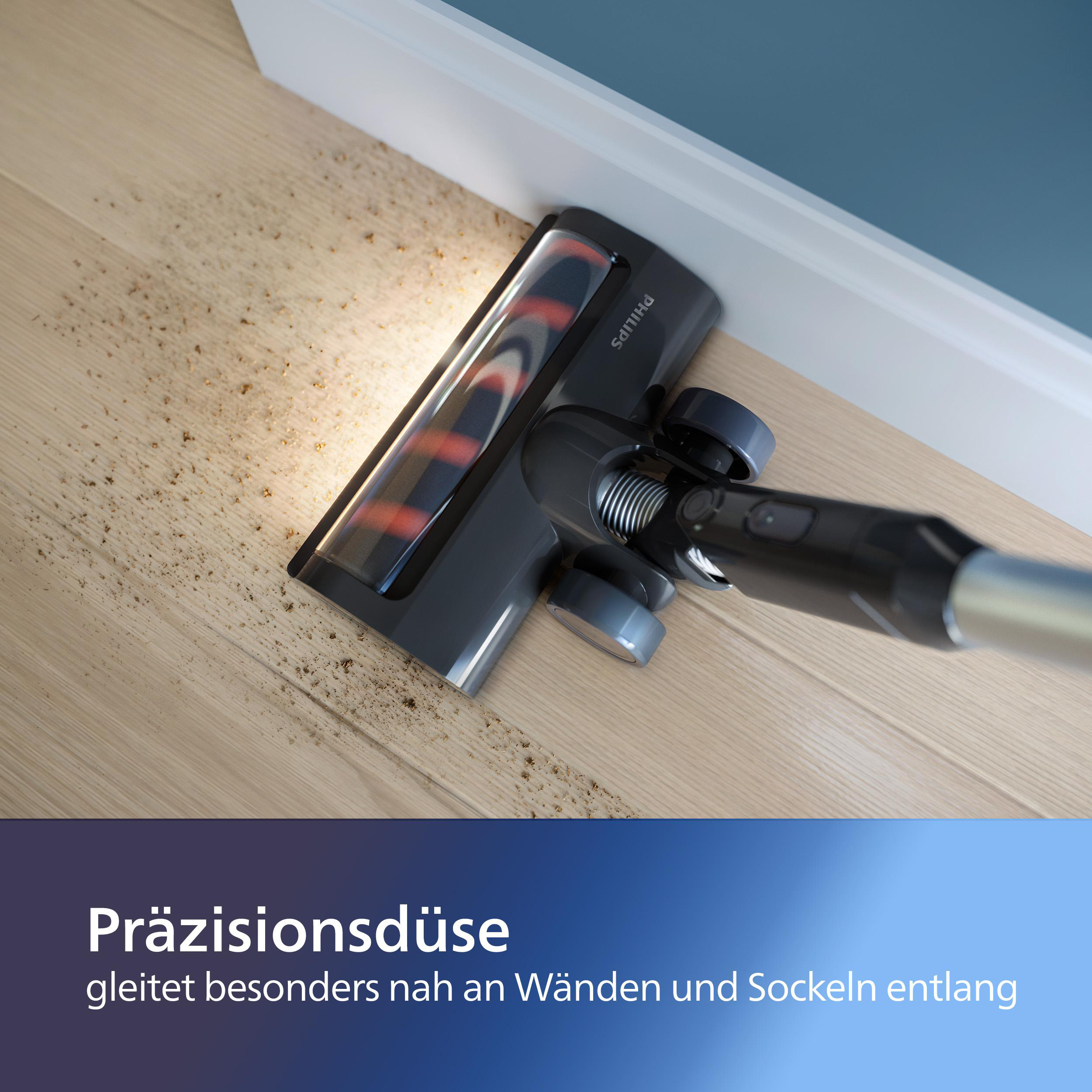Vakuumkopf reinigt nah an Wand. Staubpartikel sind sichtbar.