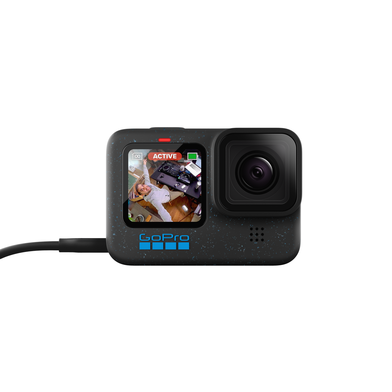 Cámara GoPro con pantalla mostrando una habitación. La cámara es negra, con cable negro conectado.