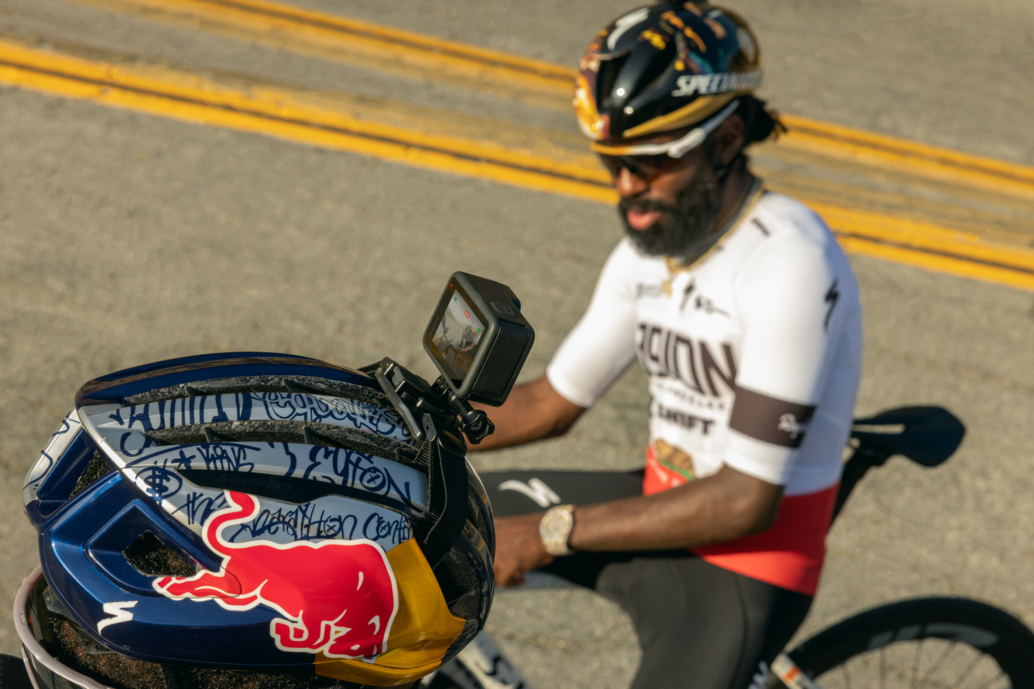 Ciclista con una cámara GoPro montada en un casco, enfocado, con fondo borroso.
