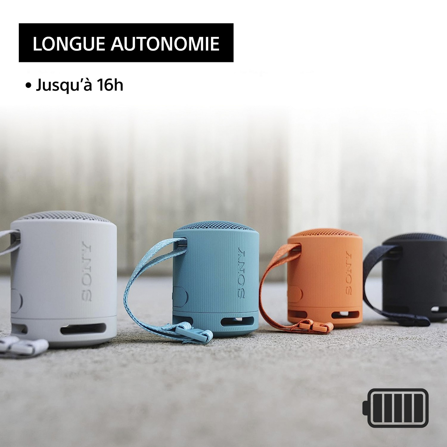 Quatre petits haut-parleurs Sony colorés avec des sangles, disposés sur un tapis, superposition de texte.