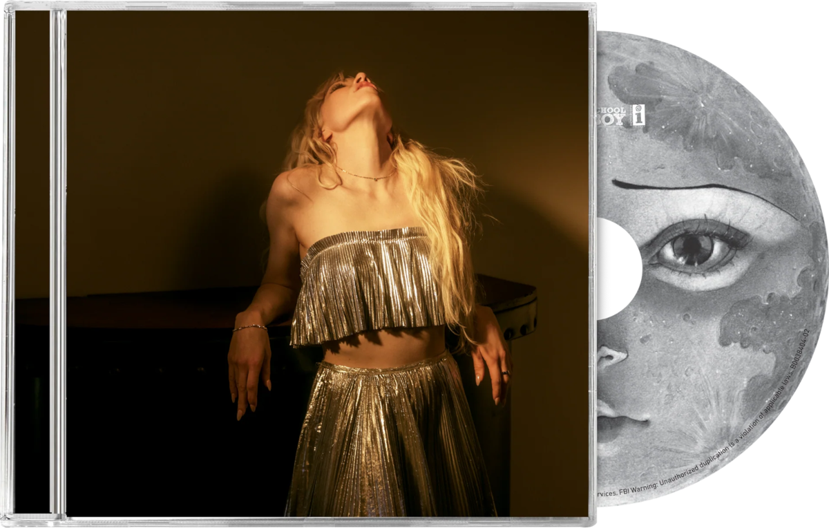 Album borító egy ezüst ruhás nővel, aki egy zongorának támaszkodik. Egy szemmel ellátott CD is látható.