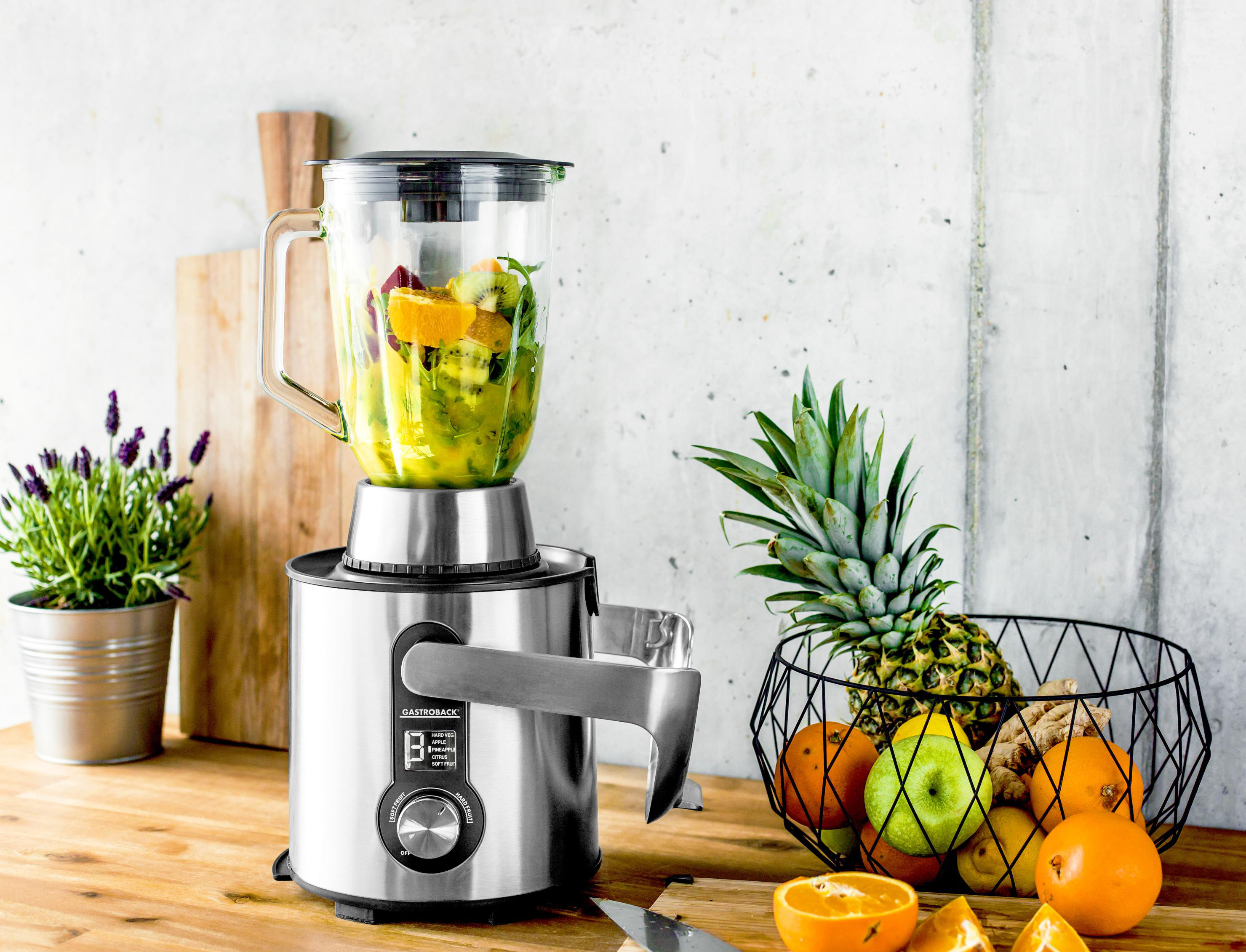 Mixer mit Früchten und Gemüse, Obstkorb, Schneidebrett und Topf mit Lavendel.