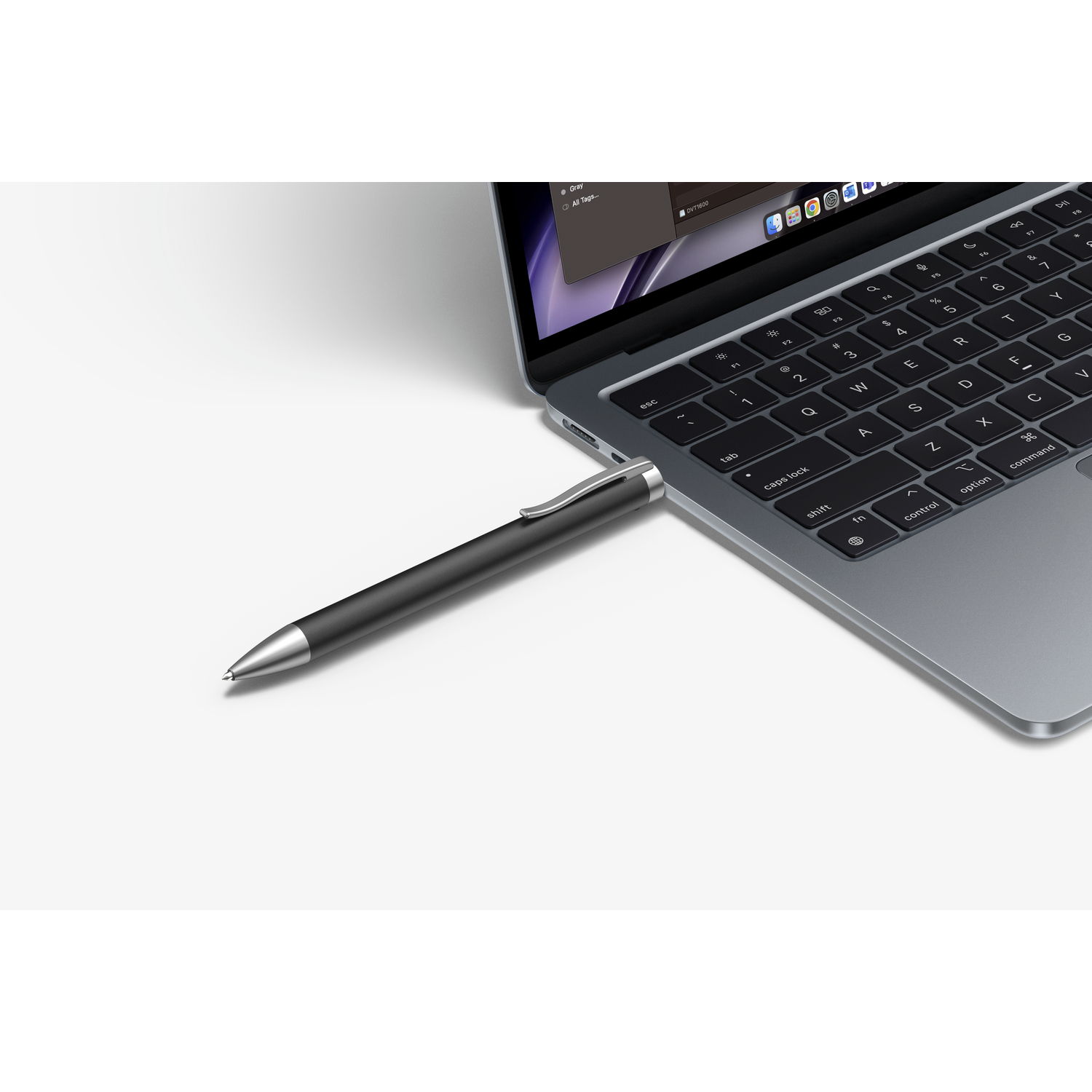 A pen-shaped USB drive plugged into a laptop, on a white surface.