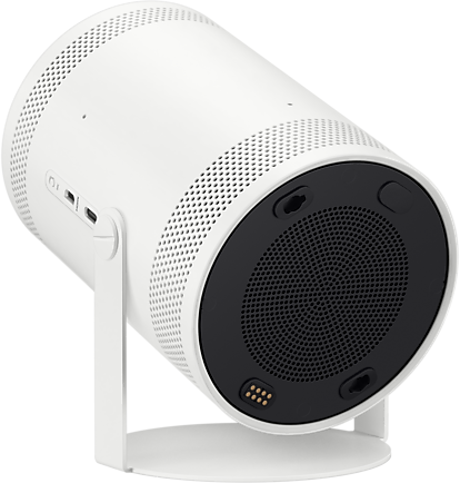 Fehér hengeres projektor állványon. Fekete hangszóró és csatlakozók alul.