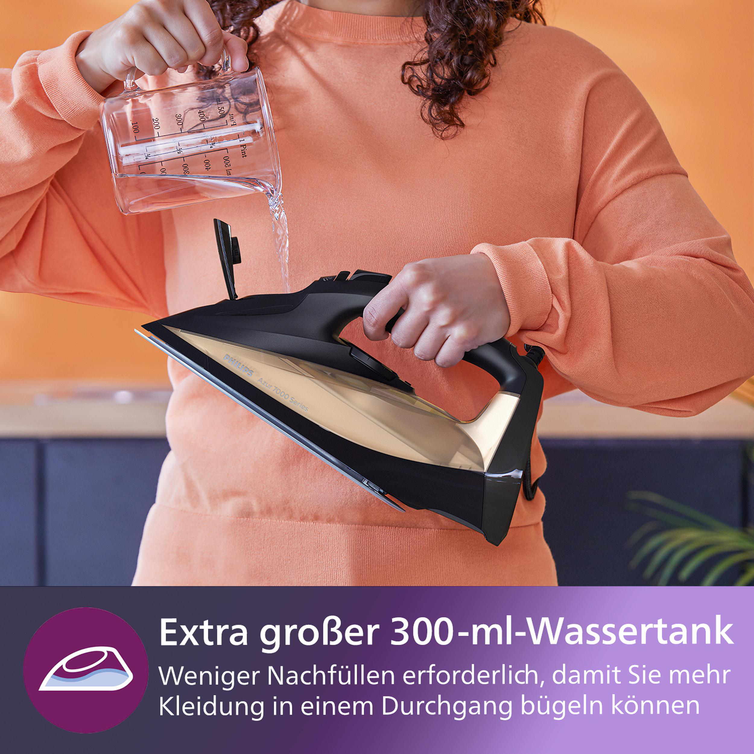 Person gießt Wasser in ein schwarz-goldenes Philips-Bügeleisen.