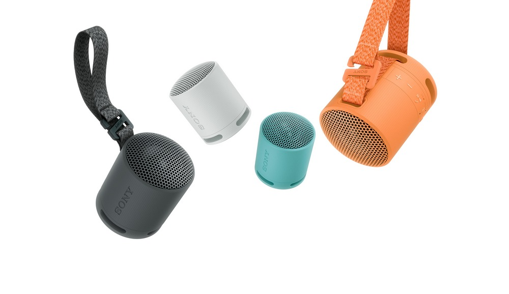 Cuatro altavoces Sony pequeños, cilíndricos, de diferentes colores, colgando de correas sobre fondo blanco.