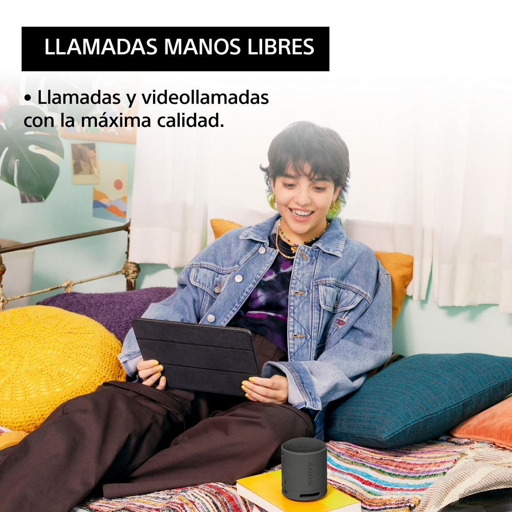 Mujer usando una tableta, con un altavoz pequeño cerca. Texto arriba: 'Llamadas manos libres'.