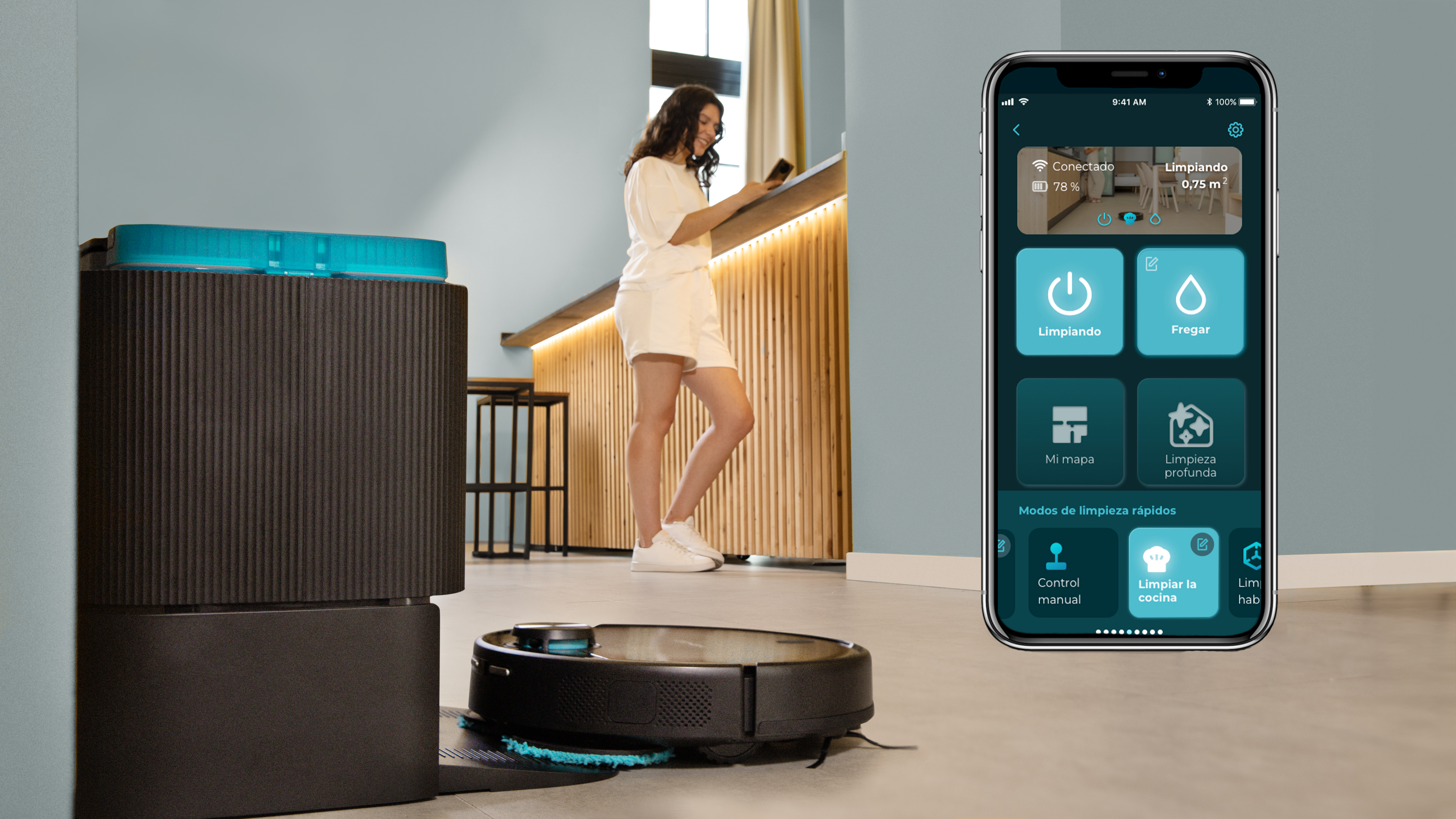 Mujer con teléfono controla un robot aspirador. El teléfono muestra opciones de limpieza. En el fondo, una cocina.
