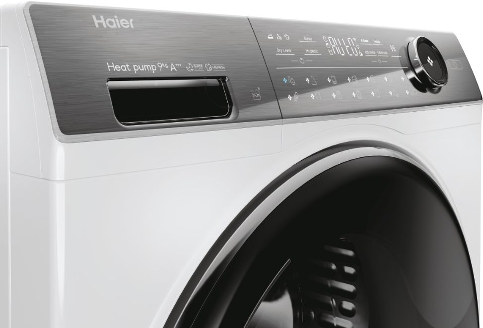 Détail du sèche-linge Haier blanc. Panneau supérieur gris avec écran et commandes. Tambour noir.