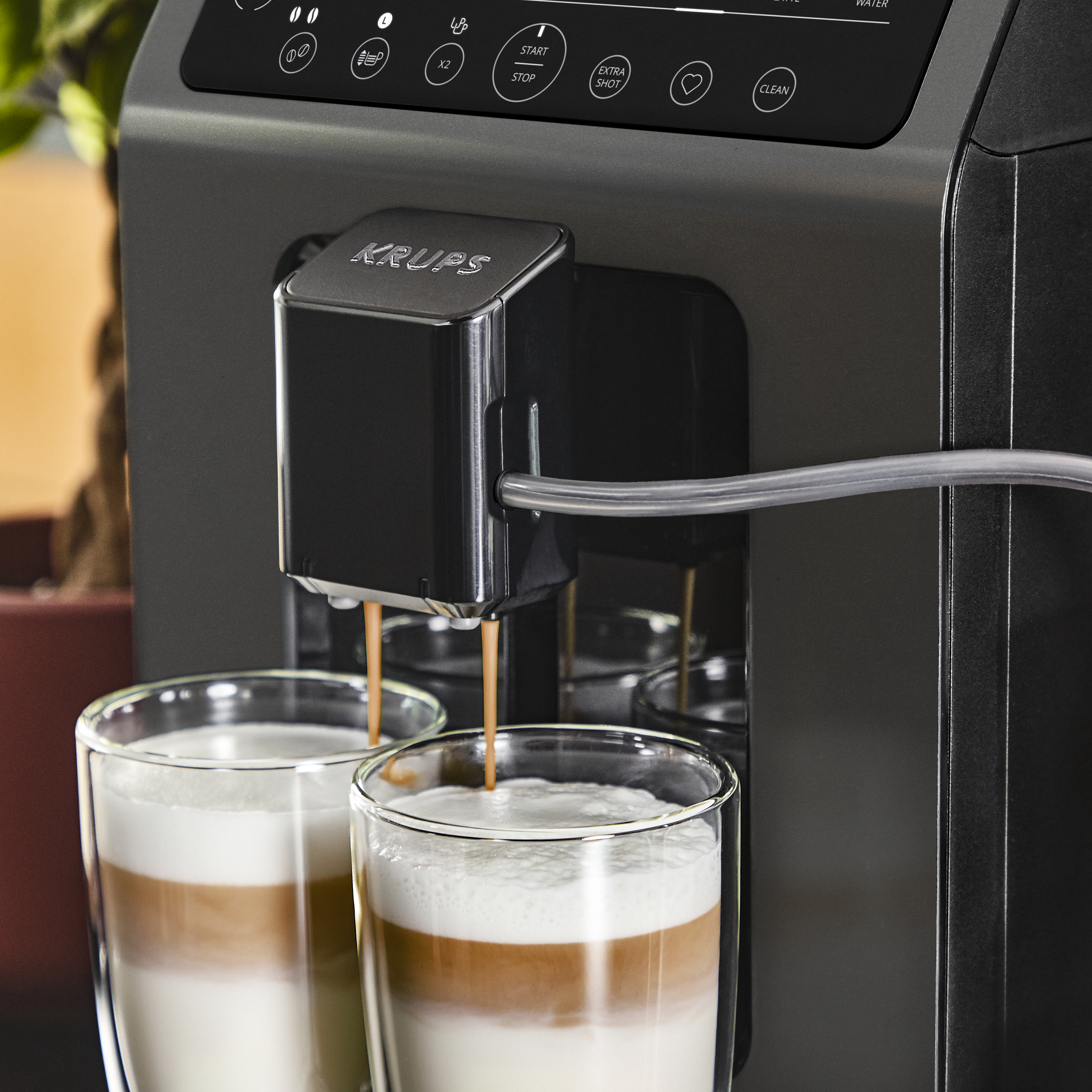 Kaffeemaschine, die Kaffee in zwei Gläser mit geschichteter Milch ausgibt.