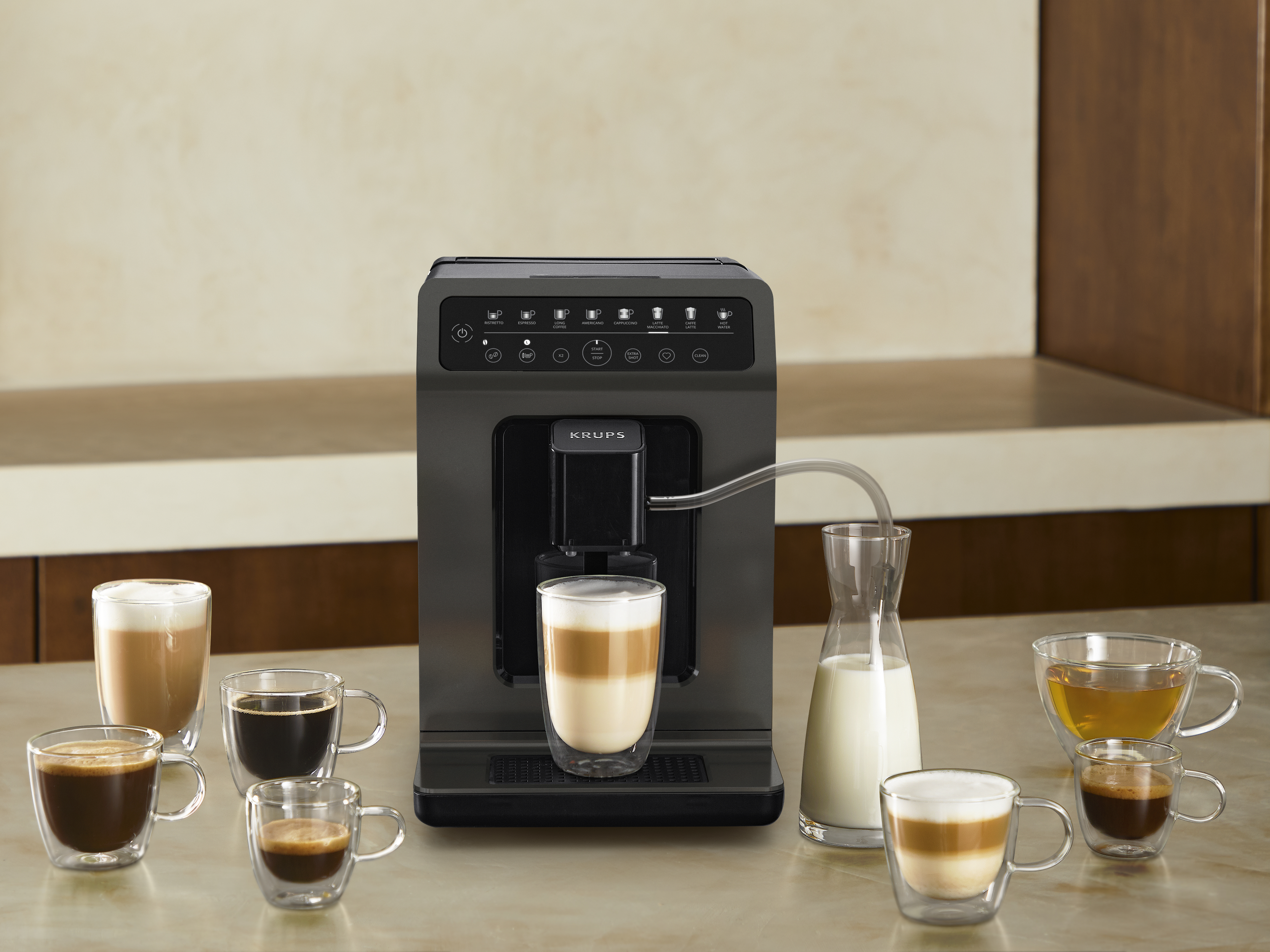 Kaffeemaschine beim Brühen von Kaffee. Verschiedene Kaffeetassen und eine Milchkanne stehen herum.