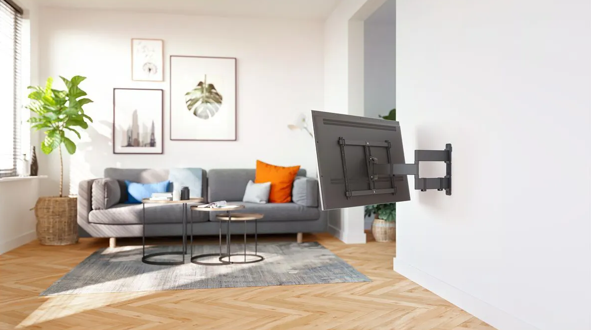 Wohnzimmer: graues Sofa, Fernseher an der Wand, Kunstwerke, Couchtische und Teppich.