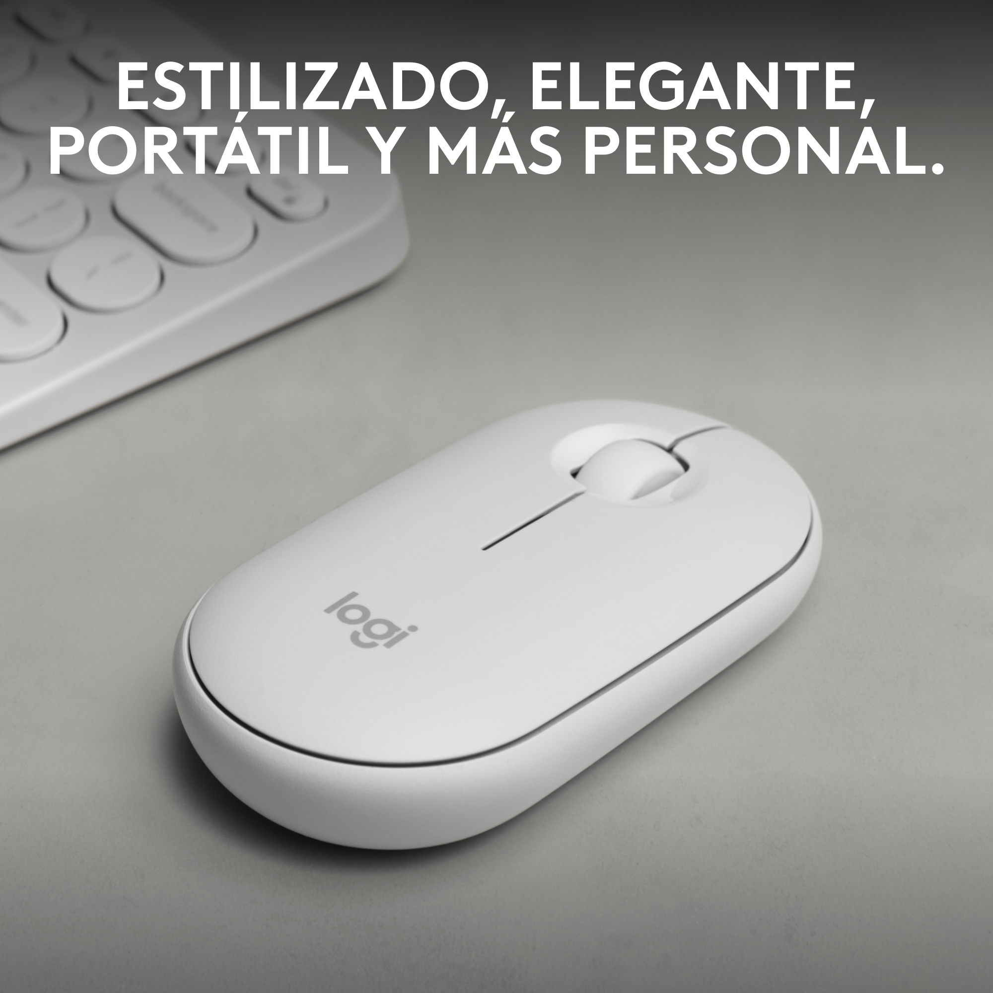 Ratón blanco con rueda de desplazamiento sobre superficie gris. Teclado blanco en el fondo.