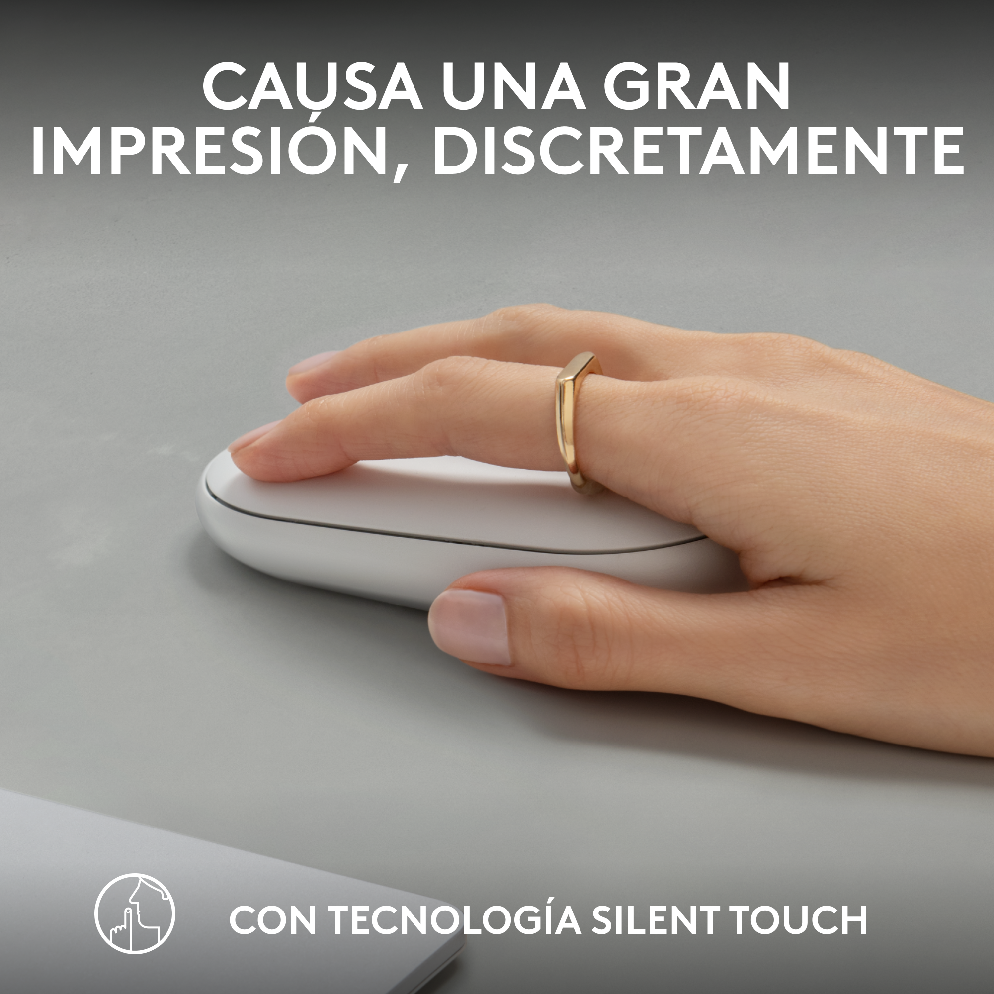 Mano con anillo en ratón. El ratón es blanco. Texto arriba: “Causa una gran impresión”.