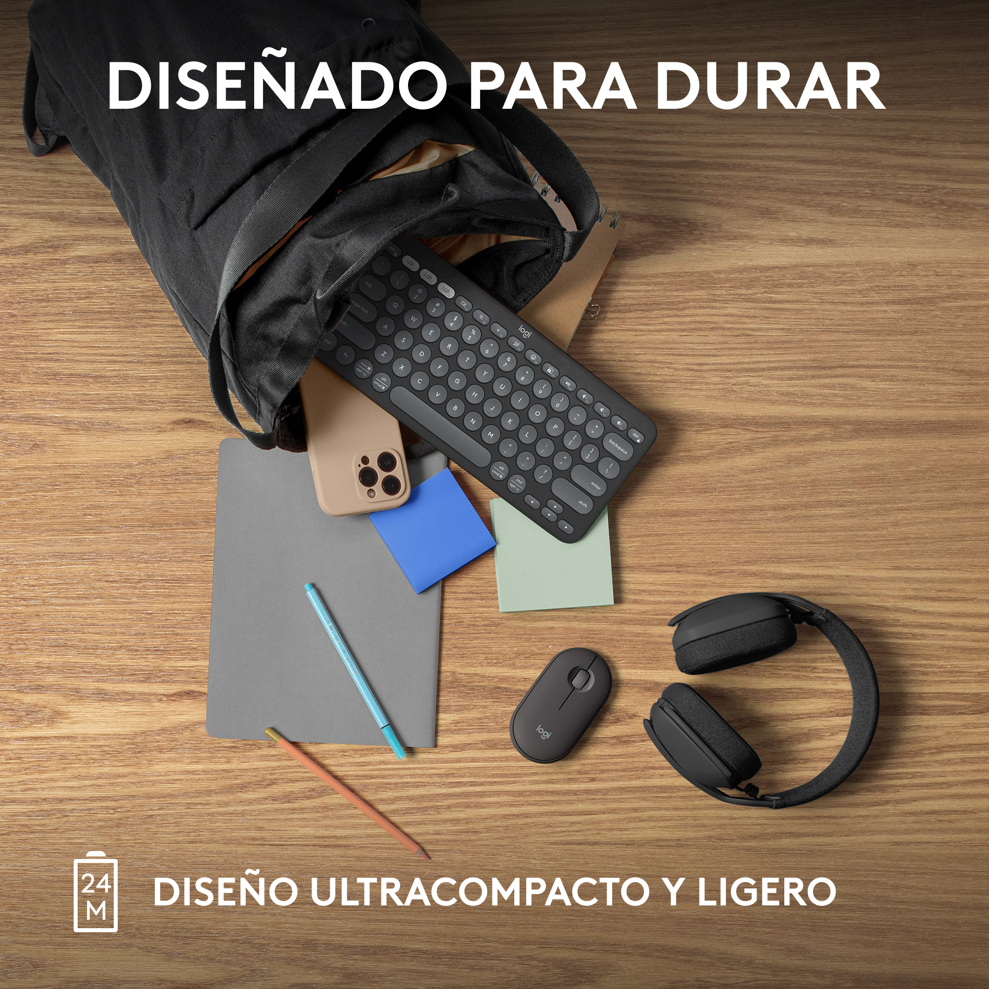 Una disposición plana con una bolsa negra, teclado, teléfono, cuaderno, bolígrafo, ratón y auriculares sobre una mesa de madera.