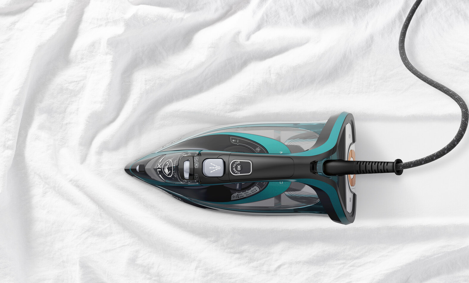 Żelazko na białej tkaninie. Żelazko jest turkusowe i czarne, z czarnym przewodem.