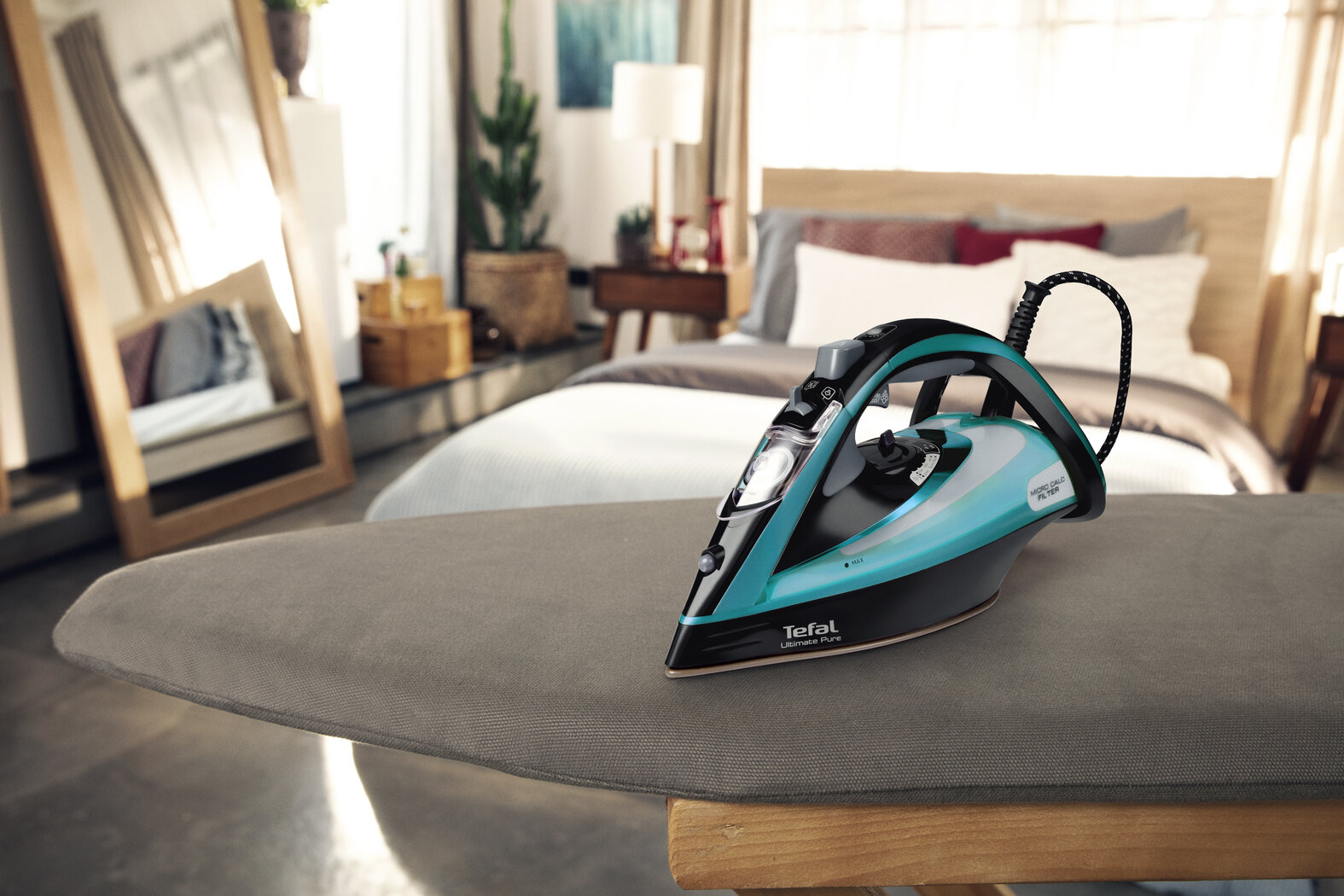 Żelazko na desce do prasowania. Tło sypialni z lustrem.