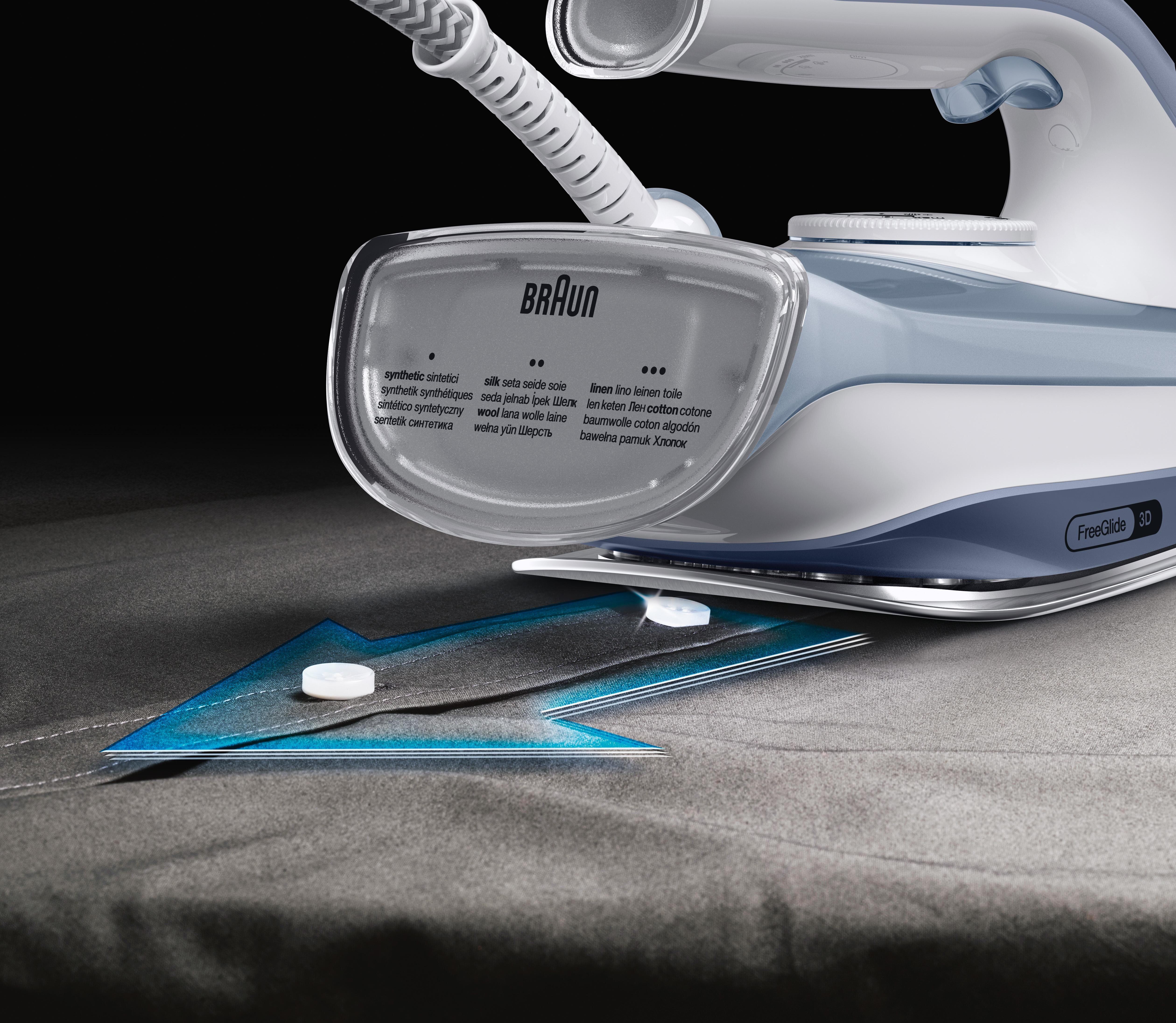 Żelazko Braun prasujące tkaninę na ciemnym tle. Żelazko ma ustawienia dla różnych tkanin.