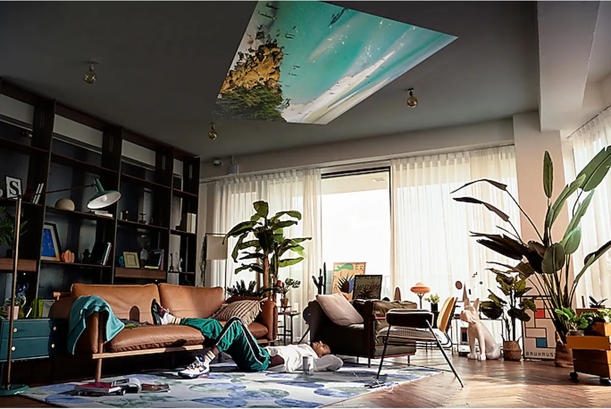 Una stanza con una proiezione sul soffitto con una persona sdraiata sul pavimento.