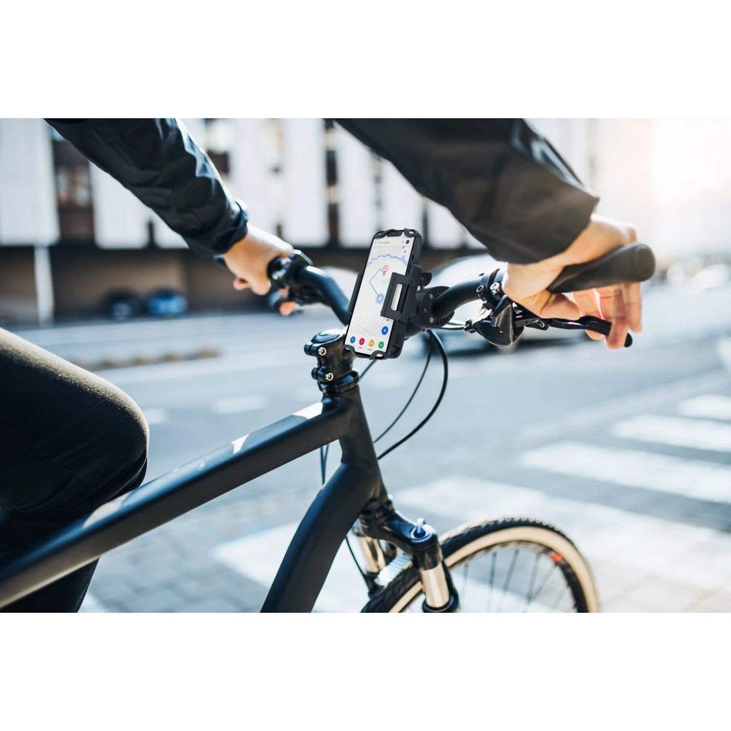 Personne faisant du vélo avec un téléphone monté sur le guidon, affichant une carte. Scène extérieure ensoleillée.