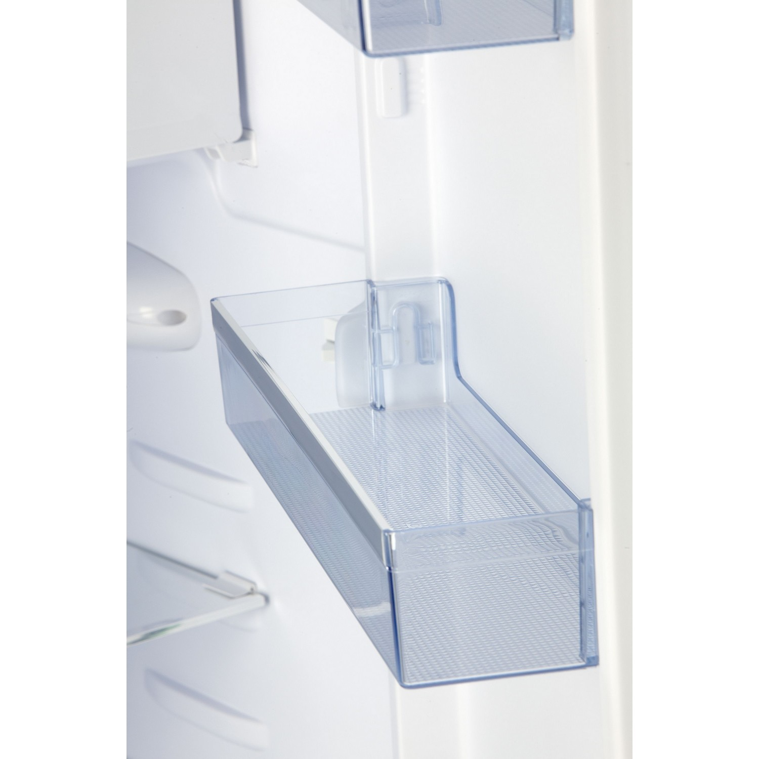 Gros plan d'un compartiment d'étagère de réfrigérateur en plastique transparent, monté dans un réfrigérateur blanc.