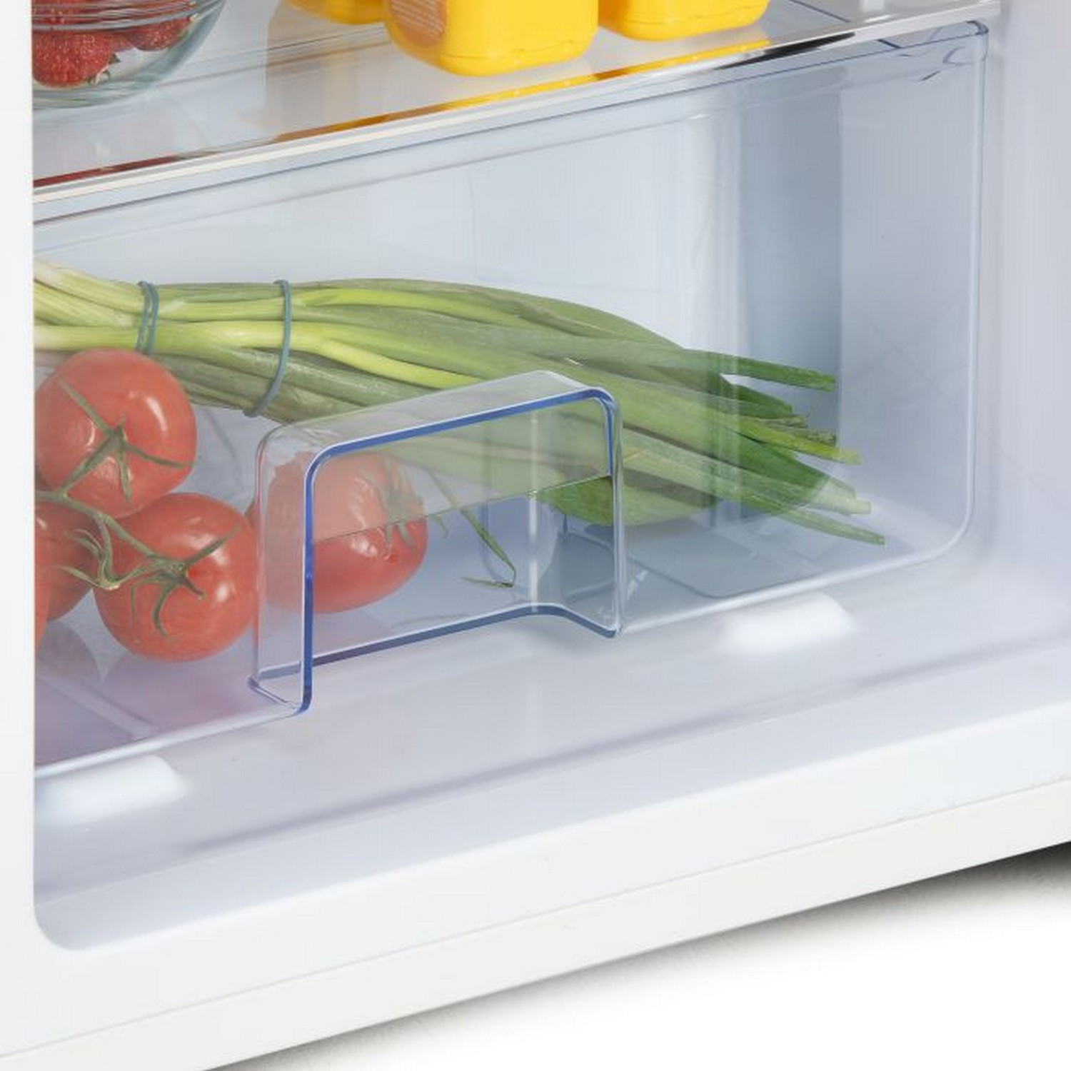 Close-up inside a refrigerator drawer, showing tomatoes and green onions.
