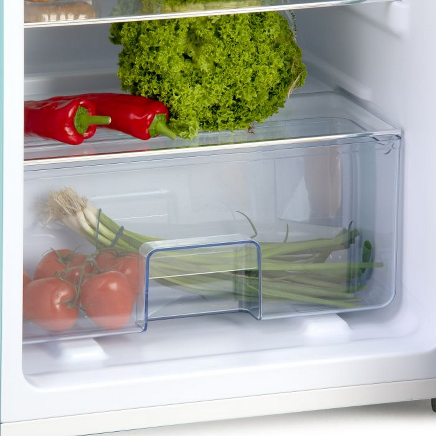 Tiroir de réfrigérateur avec des légumes : tomates, oignons verts, laitue et un poivron rouge.