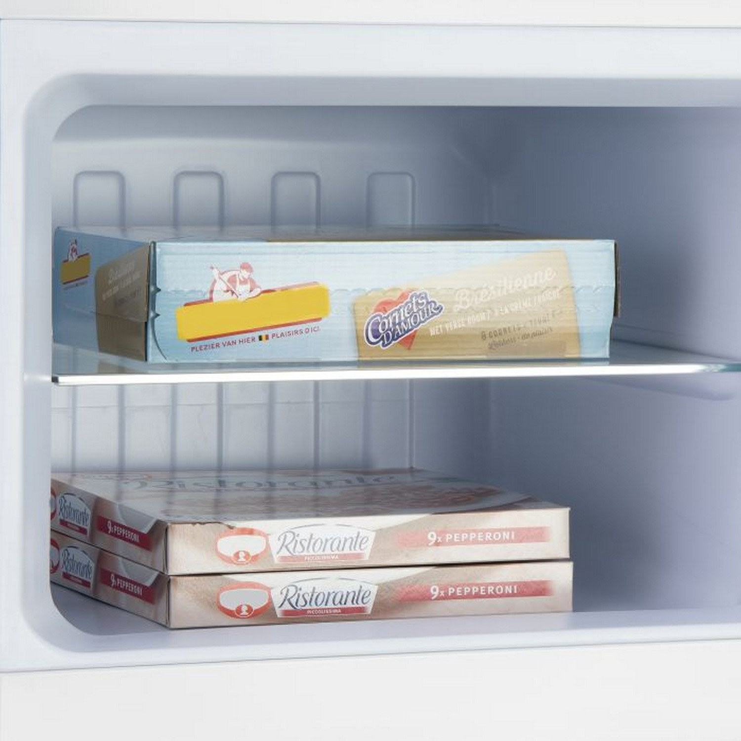 Intérieur de réfrigérateur montrant des boîtes à pizza et autres aliments.