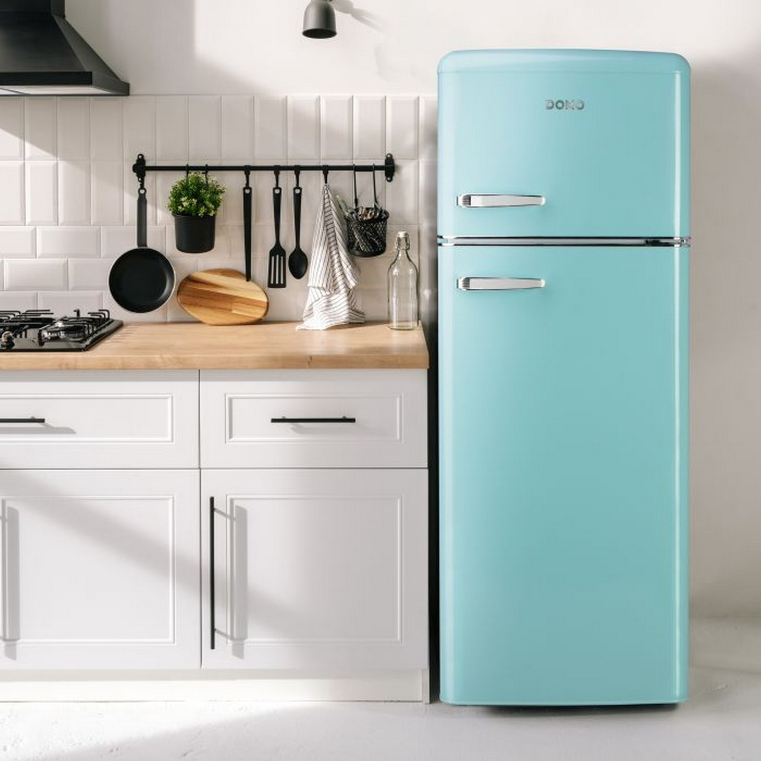Réfrigérateur turquoise de style rétro dans une cuisine. Il y a des éléments de cuisine en arrière-plan.