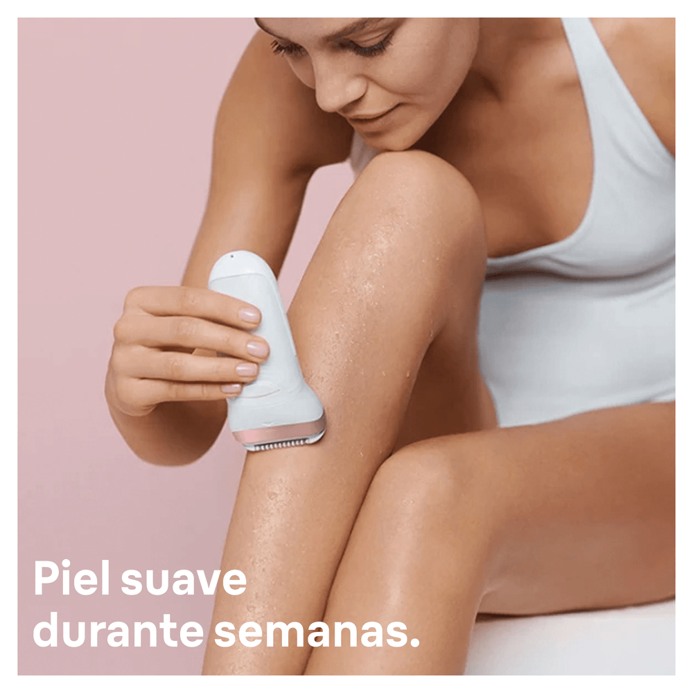 Mujer afeita la pierna con una depiladora blanca sobre un fondo rosa. El texto dice: Piel suave durante semanas.