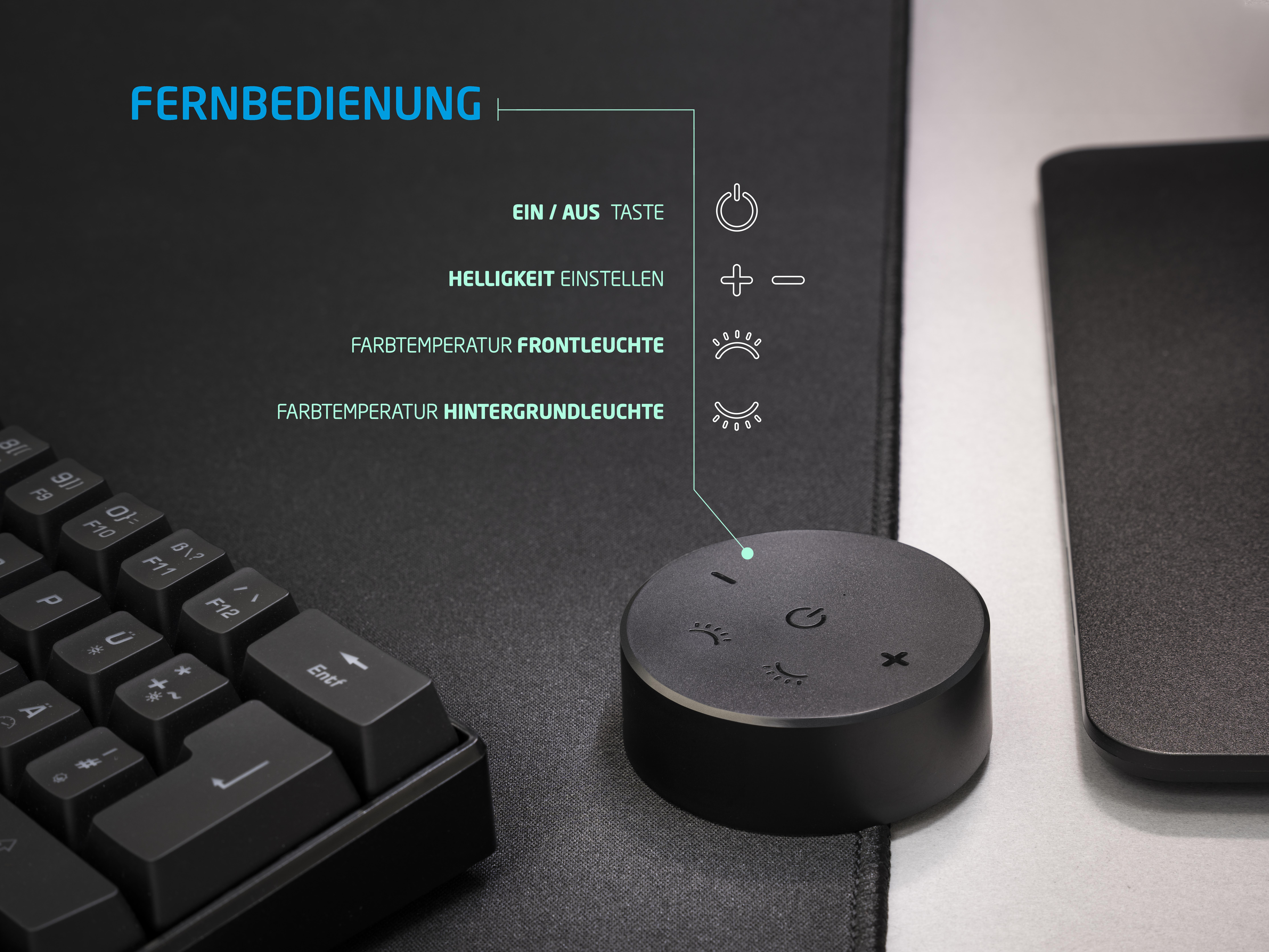 Eine schwarze Fernbedienung mit Tasten und Text, neben einer Tastatur und Maus.