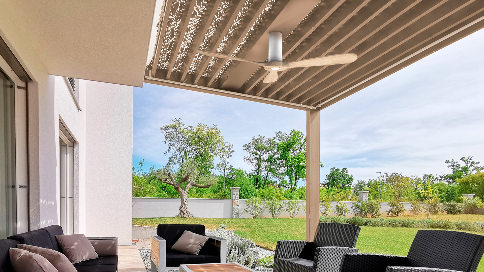 Patio al aire libre con pérgola de madera. Una casa blanca y un jardín verde están al fondo.