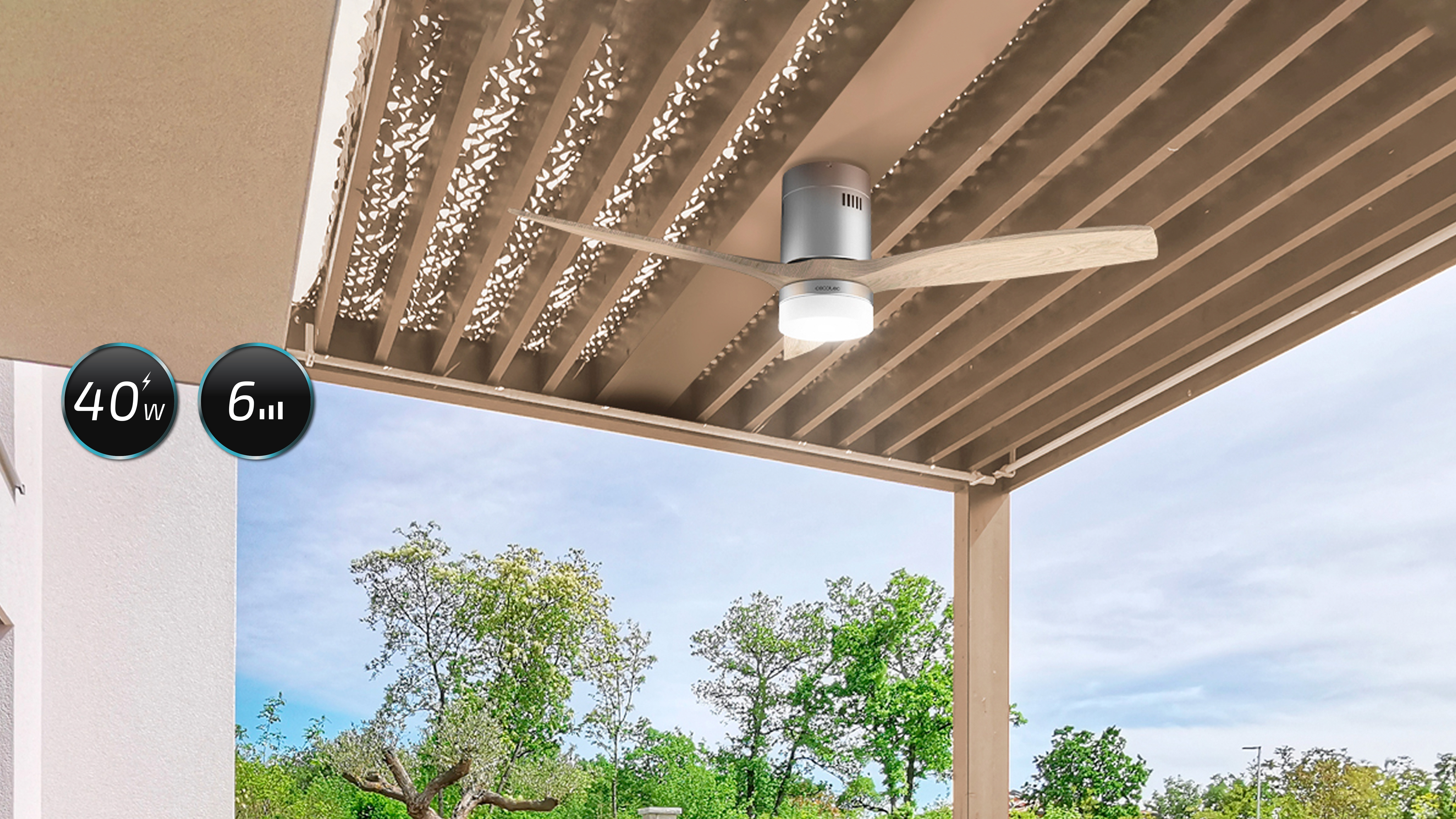 Un ventilador de techo exterior con luz. Tiene aspas de madera y está debajo de una pérgola.