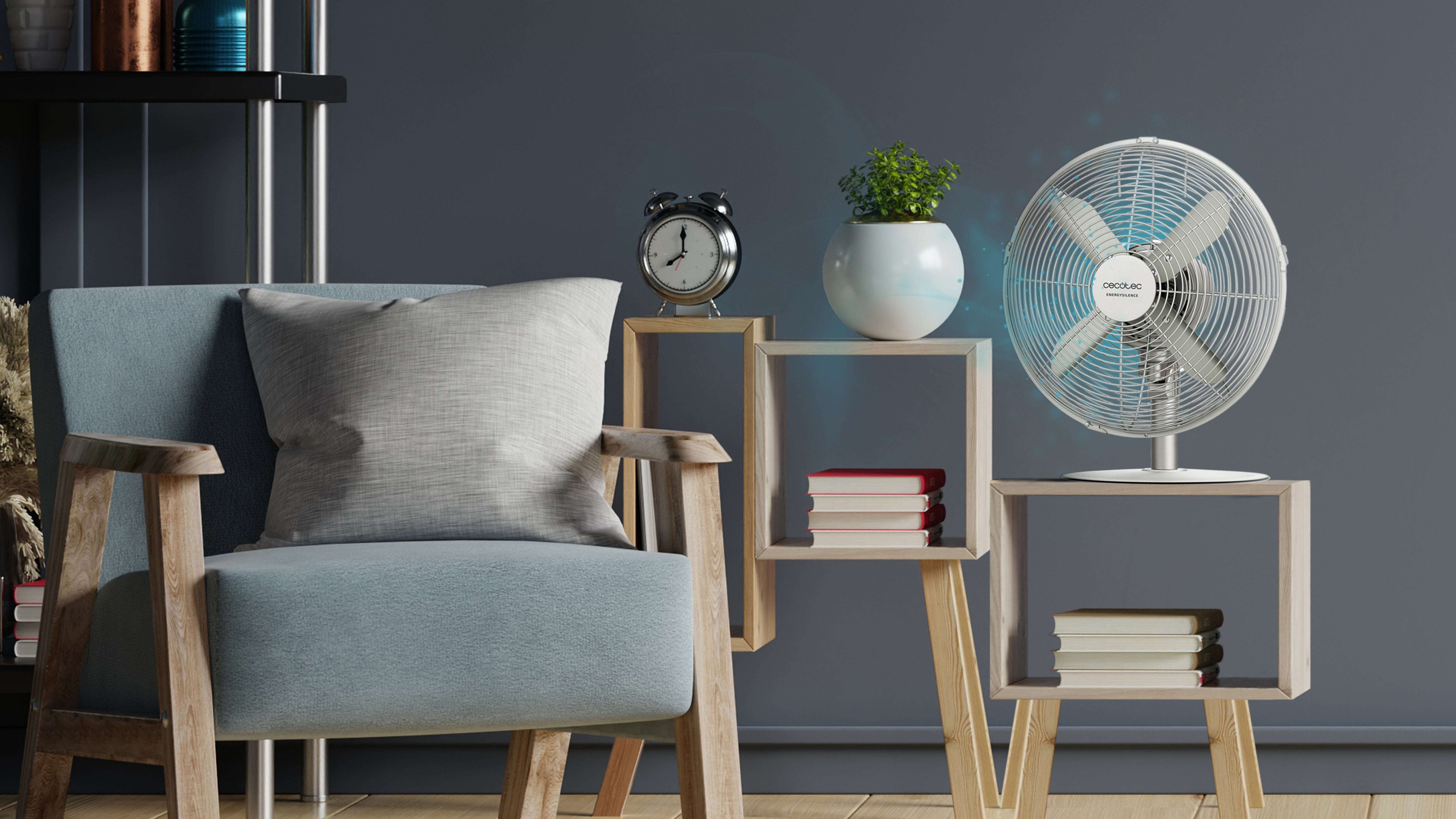 Ventilador en mesa auxiliar. Un ventilador sopla hacia una silla y una mesa auxiliar. Fondo azul oscuro.
