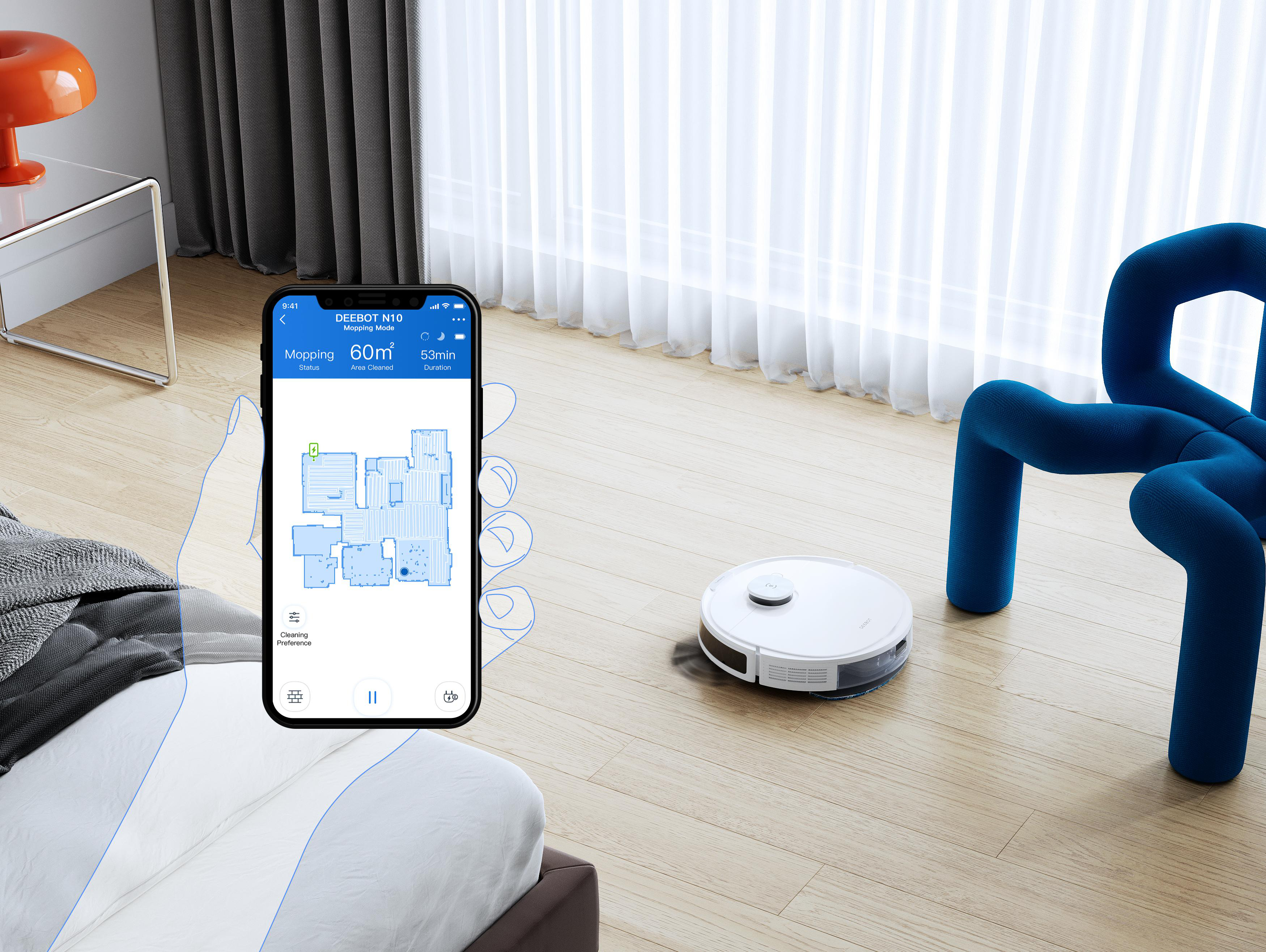 Ein Smartphone zeigt einen Grundriss, ein Roboter-Staubsauger auf dem Boden.