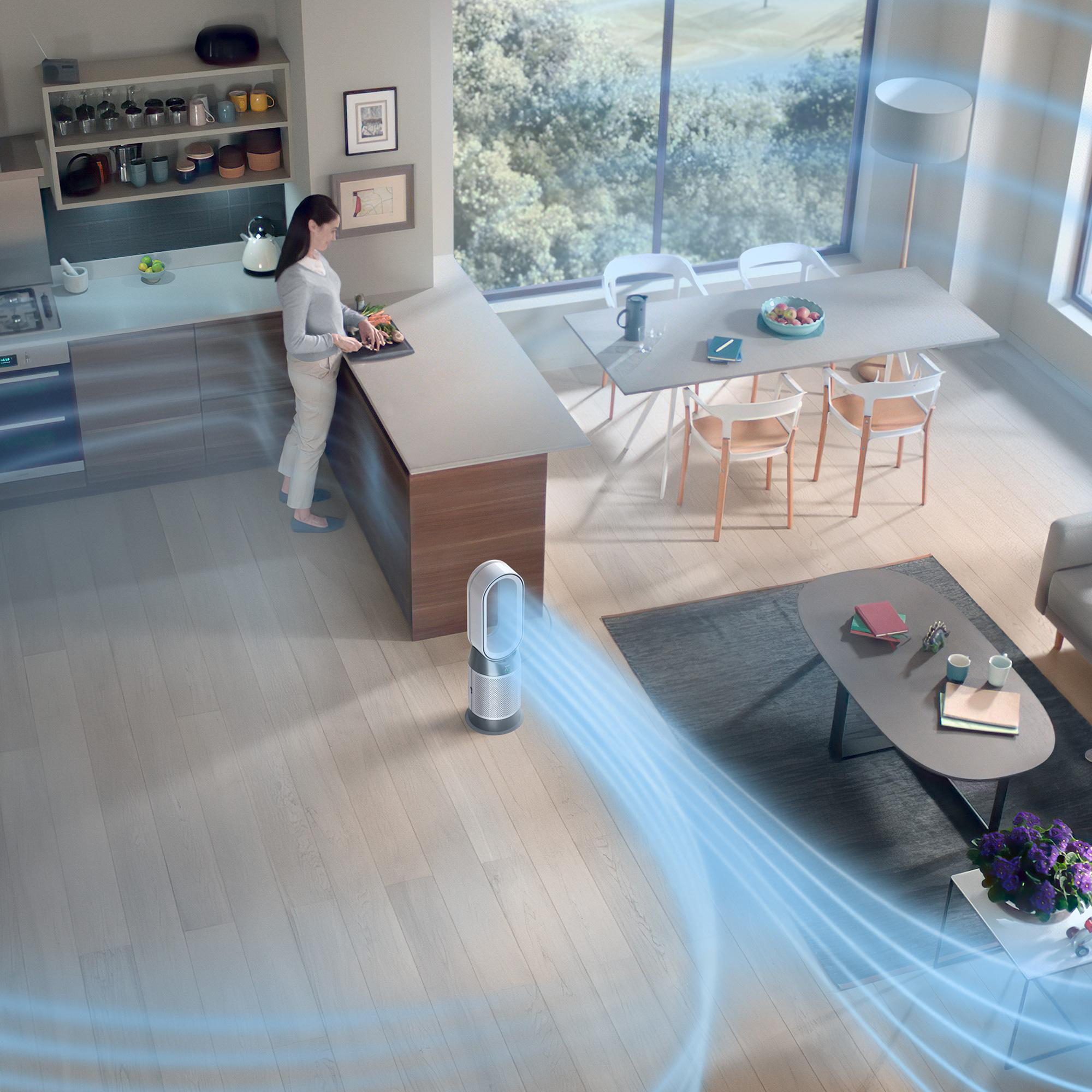 Ein modernes Interieur mit einem Dyson Luftreiniger und einer Frau in der Nähe einer Kücheninsel.