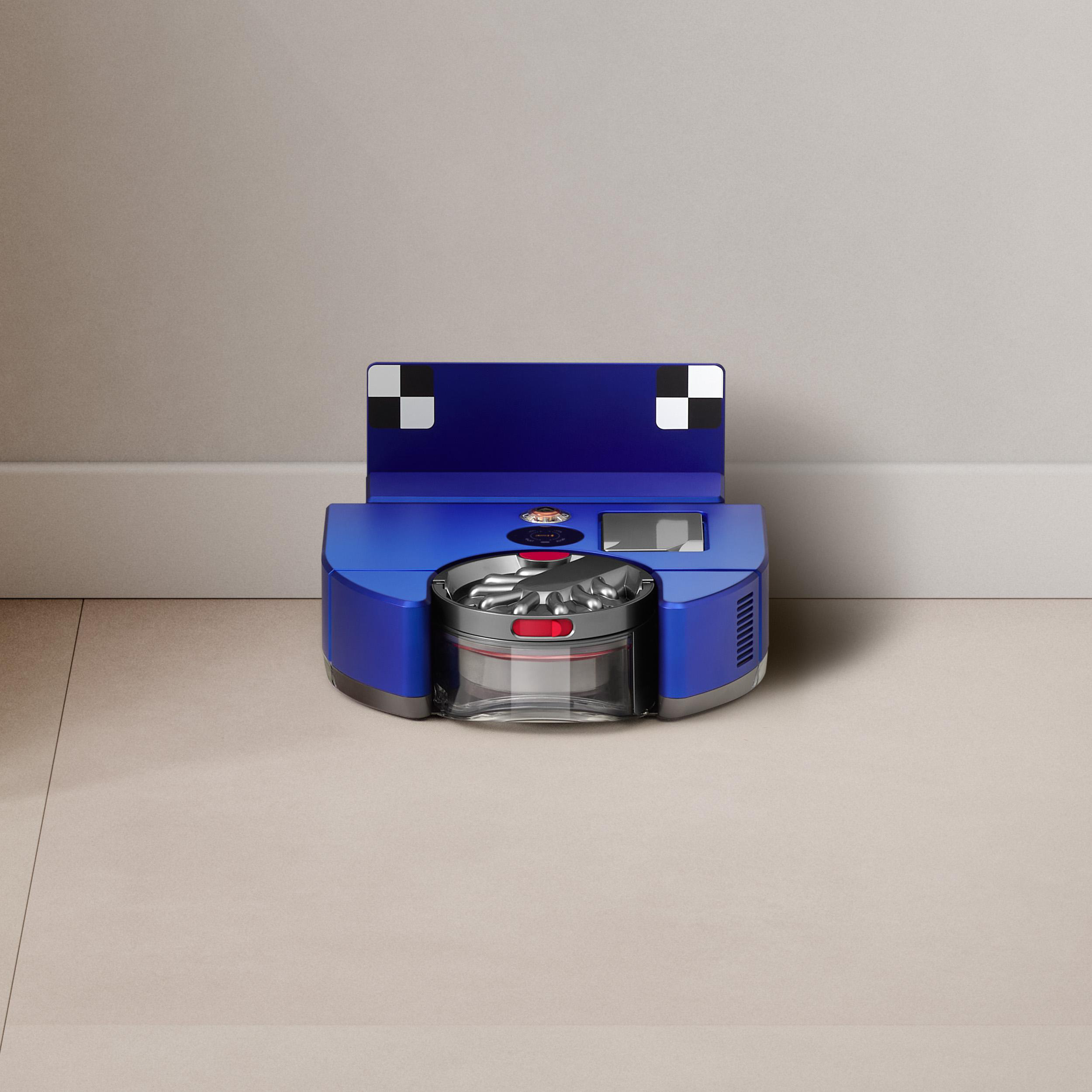Ein blauer Roboter-Staubsauger auf beigem Boden vor einer weißen Wand.