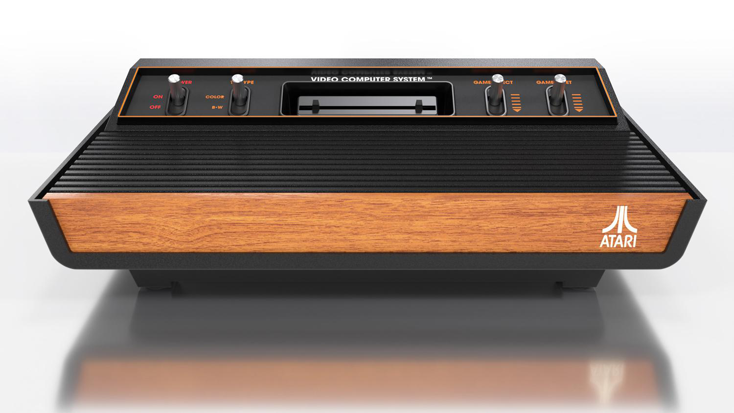 Eine klassische Atari-Videospielkonsole in Schwarz und Holzmaserung. Die Konsole steht auf einer weißen Oberfläche.