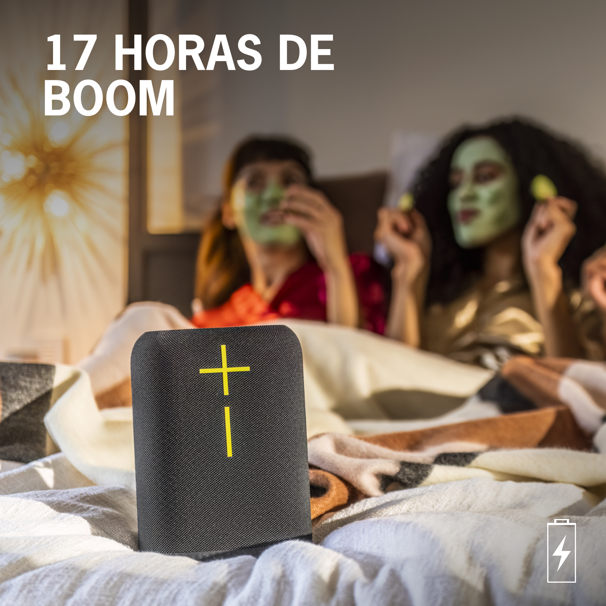 Un altavoz negro con un signo más amarillo, con dos mujeres al fondo.