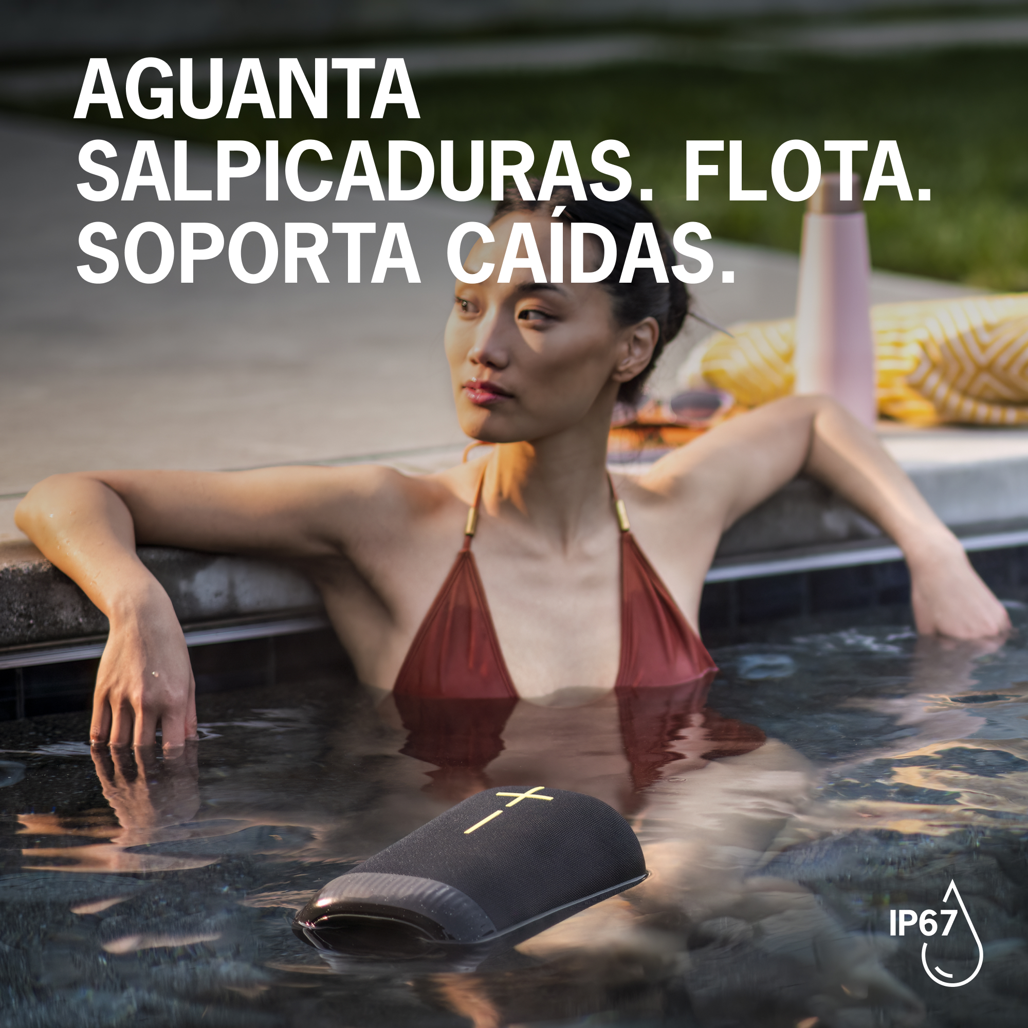 Una mujer se relaja en el agua con un altavoz negro flotante. Texto: Resistente a salpicaduras.
