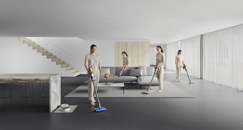 Múltiples imágenes de una mujer aspirando una sala de estar con una aspiradora Dyson. La habitación es moderna.