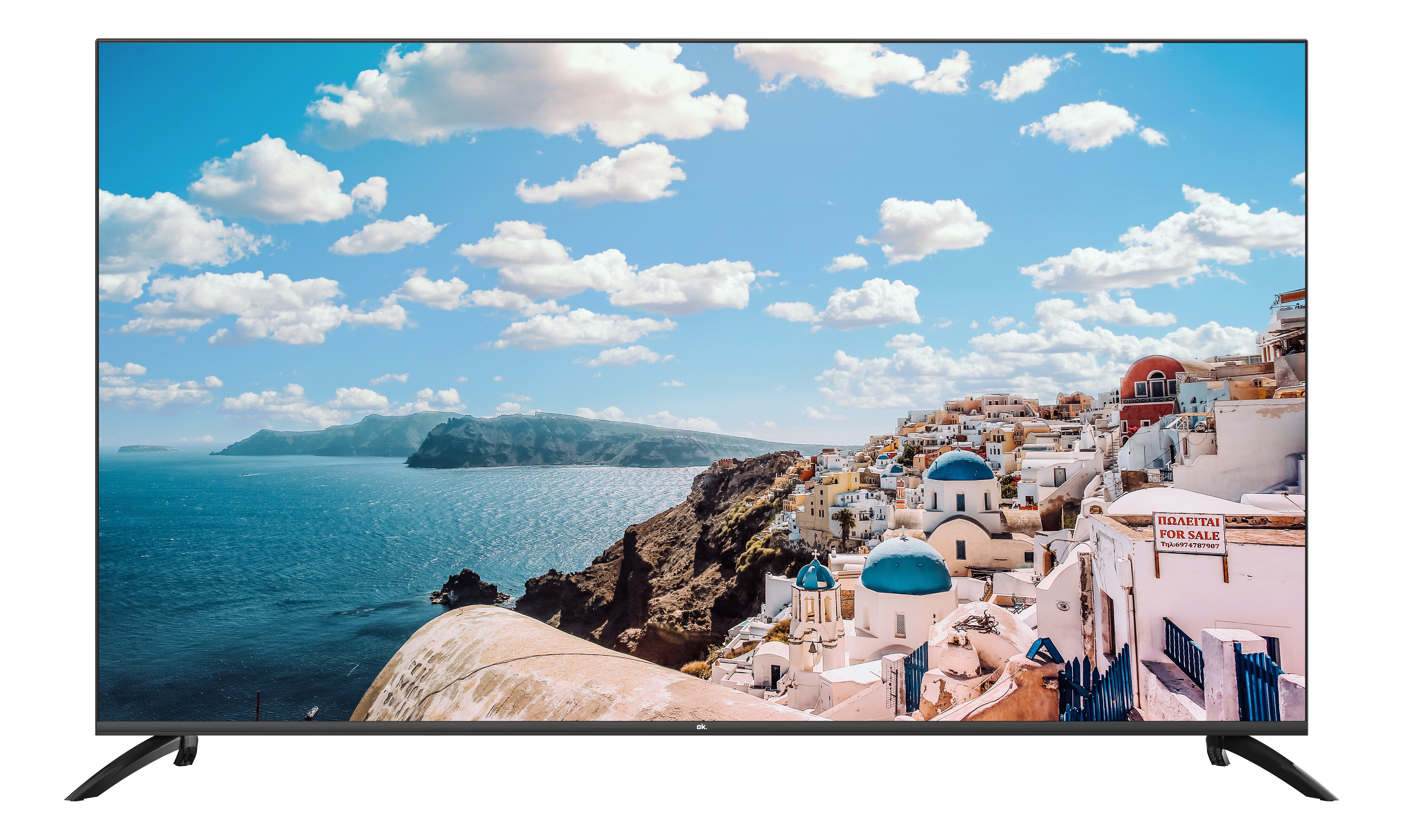 Weiße Häuser mit blauen Kuppeln am Meer unter blauem Himmel mit Wolken.