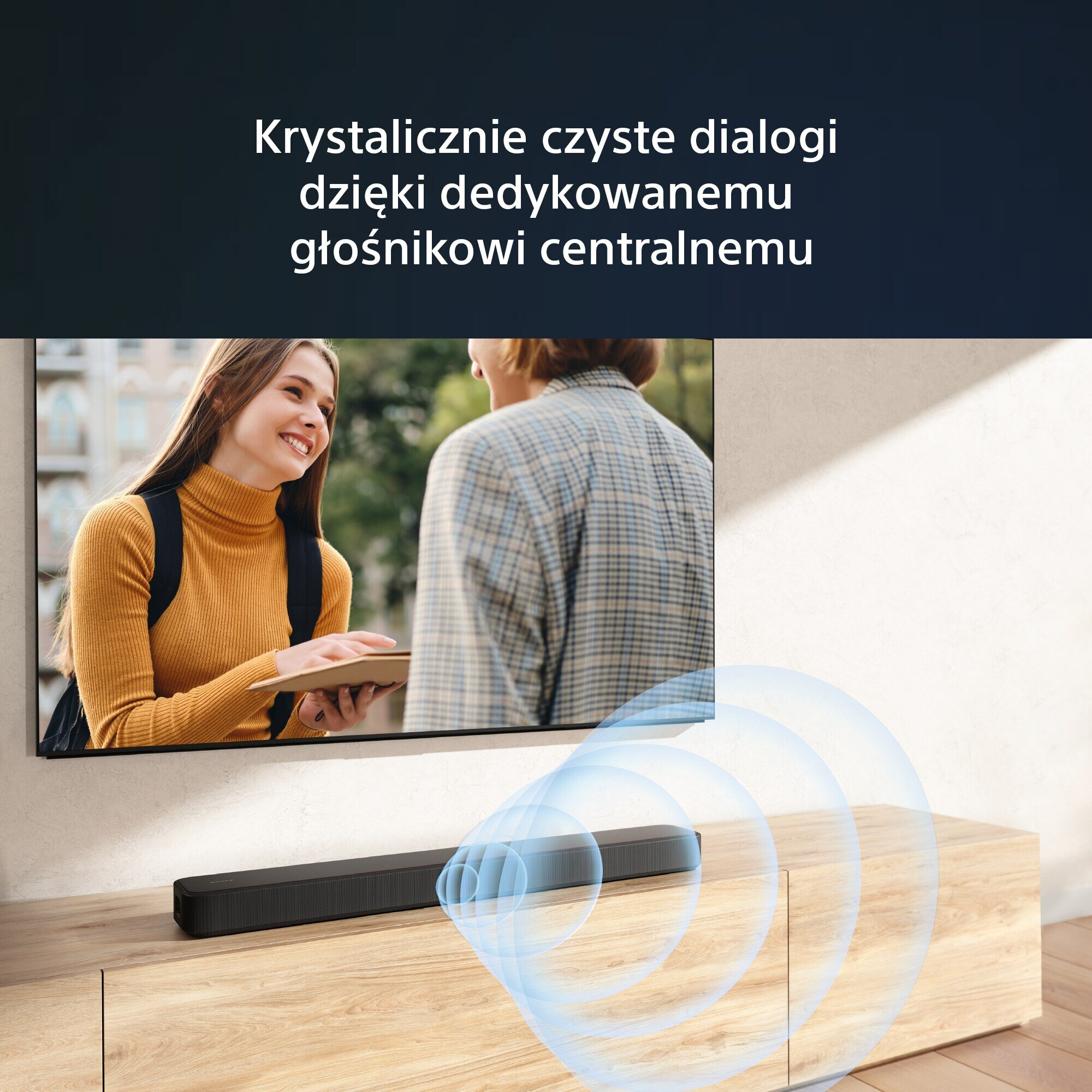 Soundbar pod telewizorem, dwie osoby w tle.