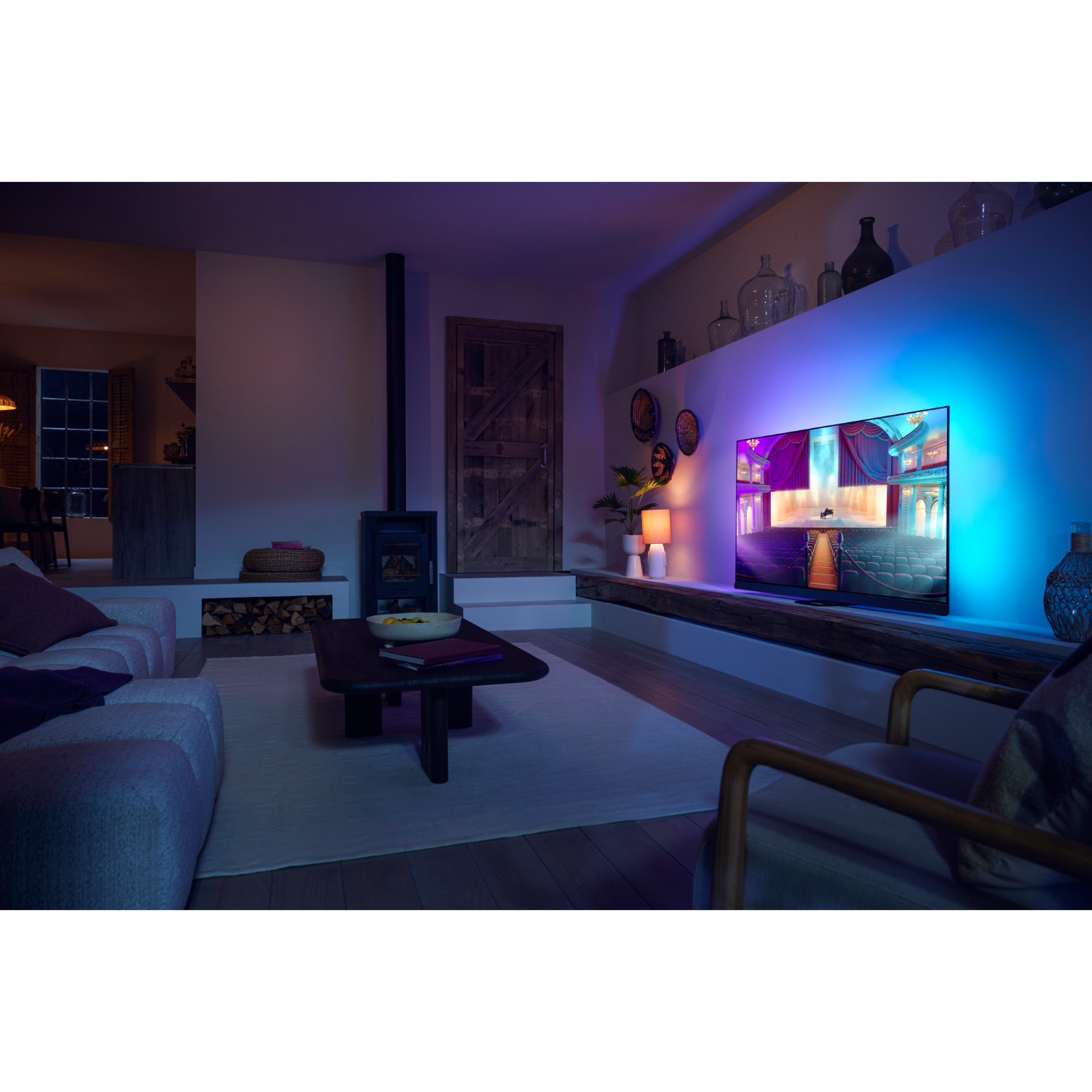 Woonkamer met tv, bank en sfeerverlichting.