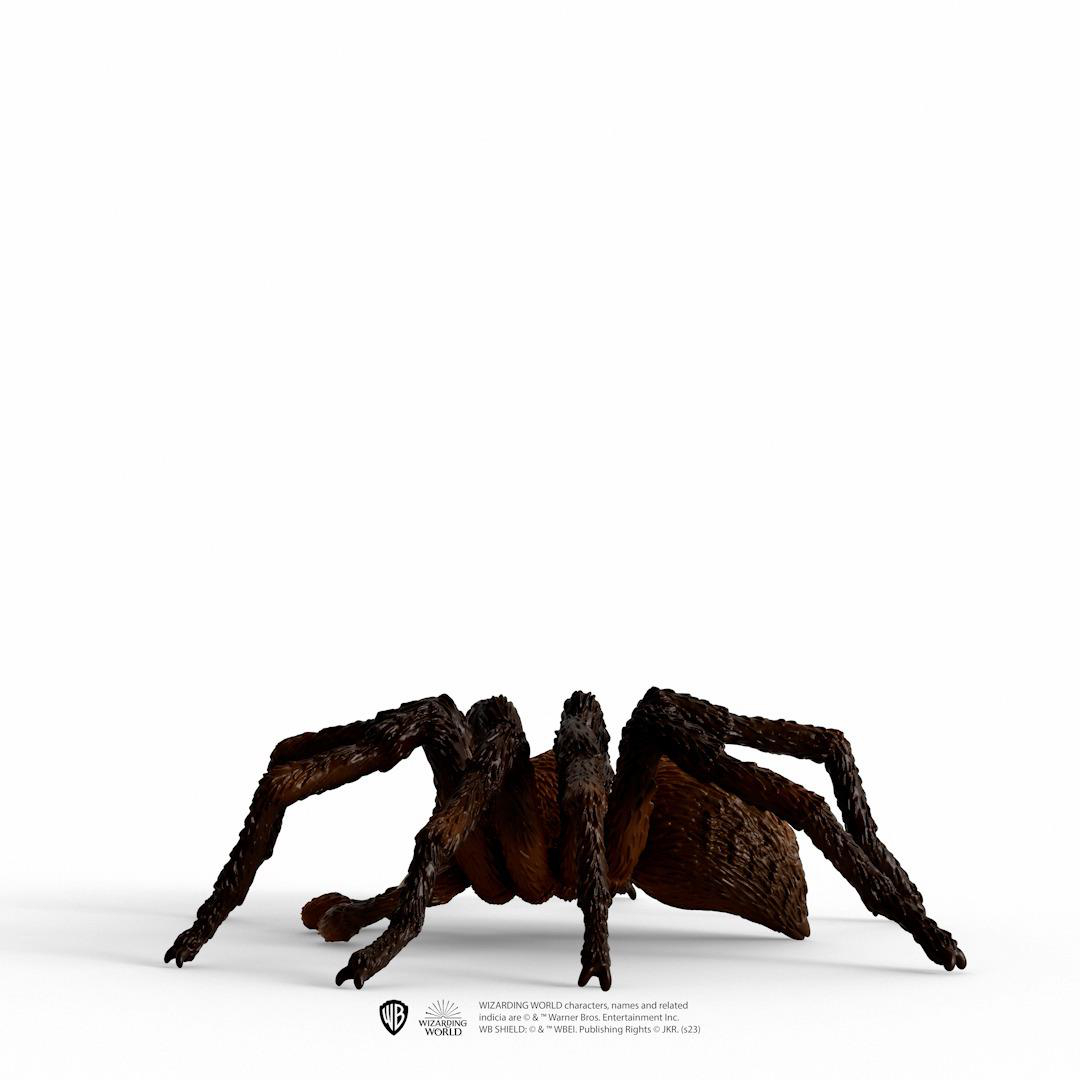 Große braune Spinne auf weißer Oberfläche mit WB-Logo.
