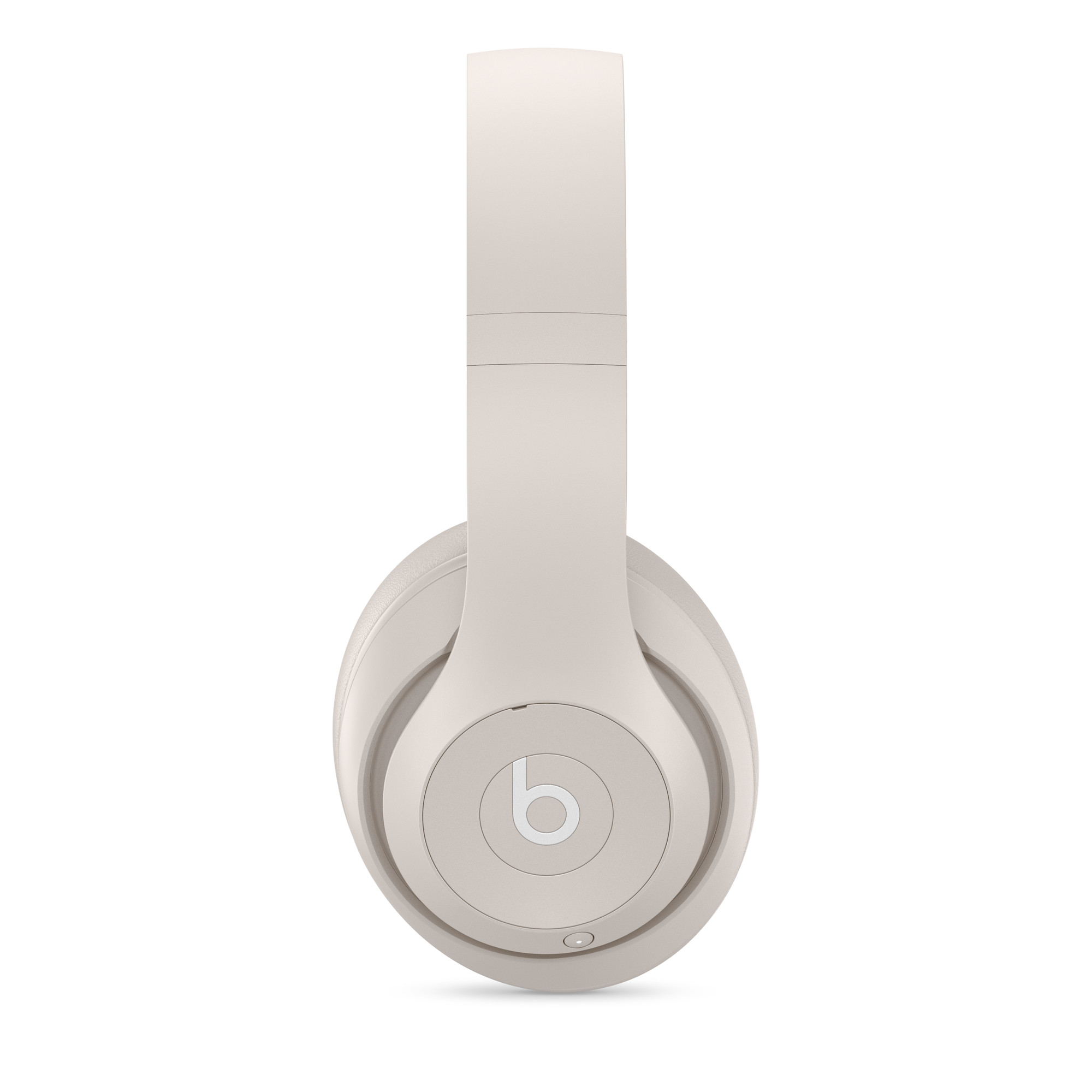 Bej Beats kulaklık. Kulaklıklar beyaz bir arka plan üzerinde. Beats logosu kulakta.