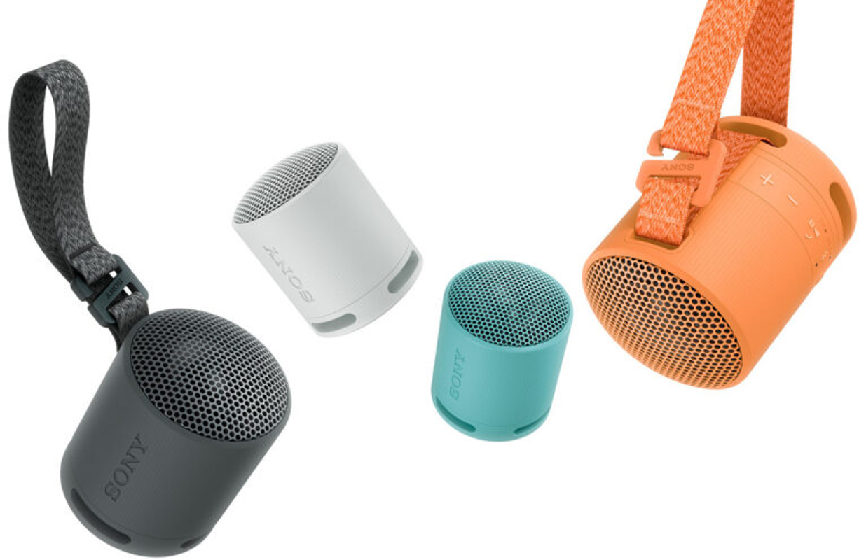 Quatre petits haut-parleurs colorés. Un gris, un blanc, un turquoise et un orange.